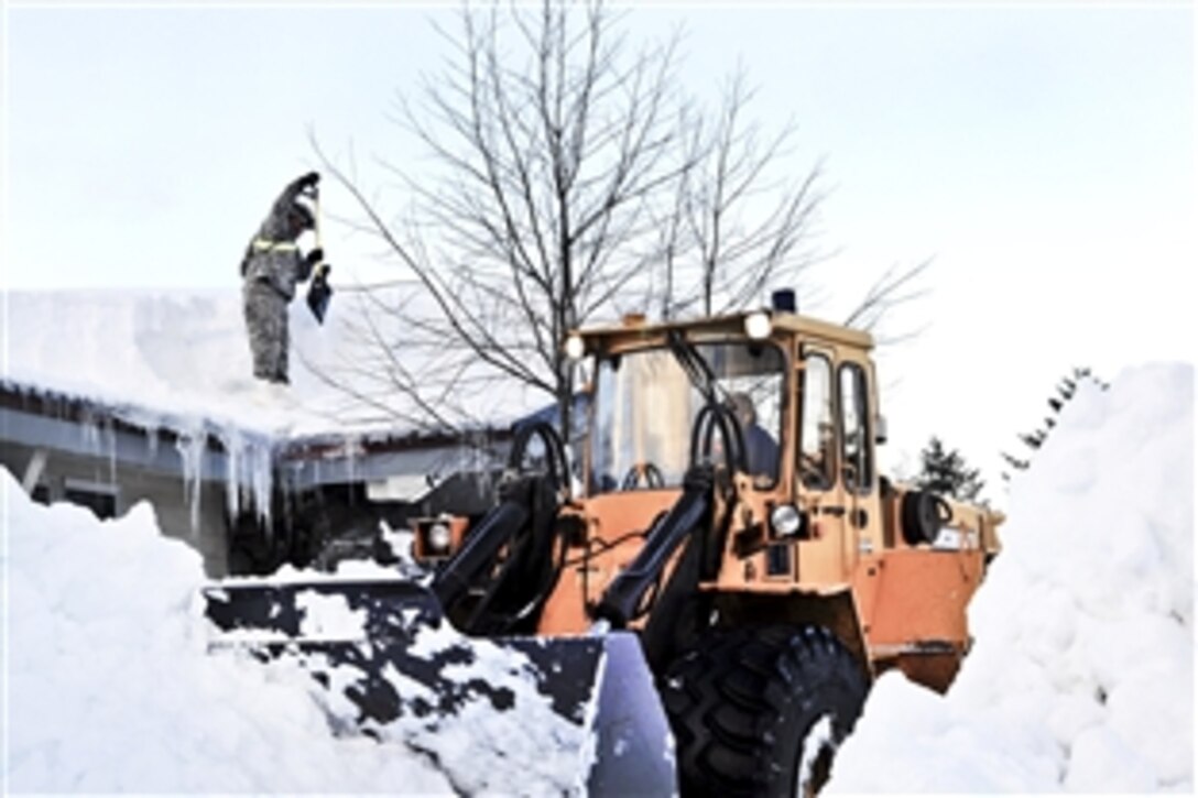 Alaska Army National Guardsmen use shovels and heavy equipment to clear an area around a building in Cordova, Alaska, Jan. 9, 2012. Guardsmen cleared roads, roofs and boats after a series of winter storms dropped nearly 18 feet of snow on the region.