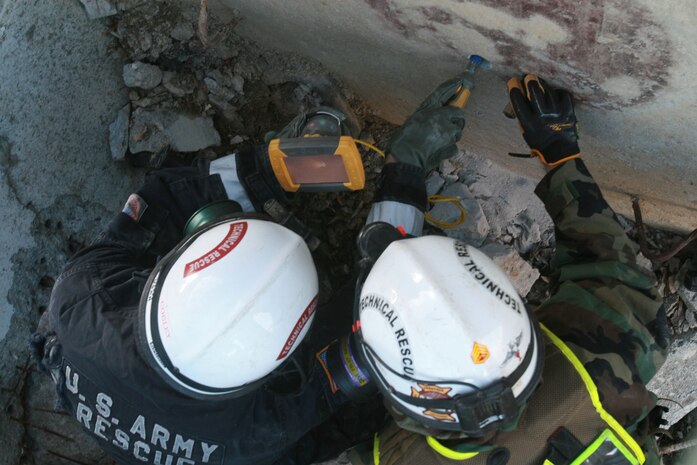 A soldier from 911th U.S. Army Technical Rescue Engineer Company and a Marine with Chemical Biological Incident Response Force’s Technical Rescue Platoon asses the condition of the void on the opposite side of a concrete barrier before breaking through to potentially rescue trapped victims in the void of a simulated collapse. This joint 72-hour technical rescue training operation with the 911th U.S. Army Technical Rescue Engineer Company at Downey Responder Training Facility allowed the two units take the opportunity to train together to build a good working relationship and familiarity of each other’s capabilities and limitations. Since both units cover the National Capitol Region, in the event of a disaster both units would work side by side.
