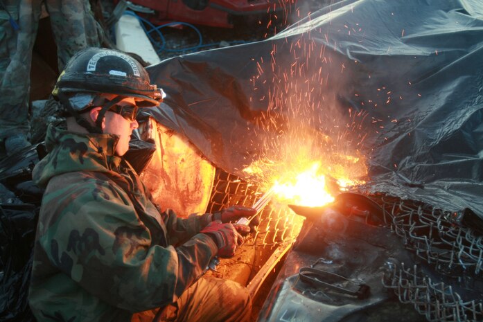 Cpl. Nathaniel James a Technical Rescue Marine with Chemical Biological Incident Response Force's (CBIRF) Initial Response Force (IRF) B's Technical Rescue platoon cuts through the front of a crushed vehicle to gain access to a tunnel where rescuers believe “victims” could be trapped during a simulated collapse. The joint 72-hour technical rescue training operation with the 911th U.S. Army Technical Rescue Engineer Company at Downey Responder Training Facility allowed the two units to take the opportunity to train together to build a good working relationship and familiarity of each other’s capabilities and limitations. Since both units cover the National Capitol Region, in the event of a disaster, both units would work side by side.