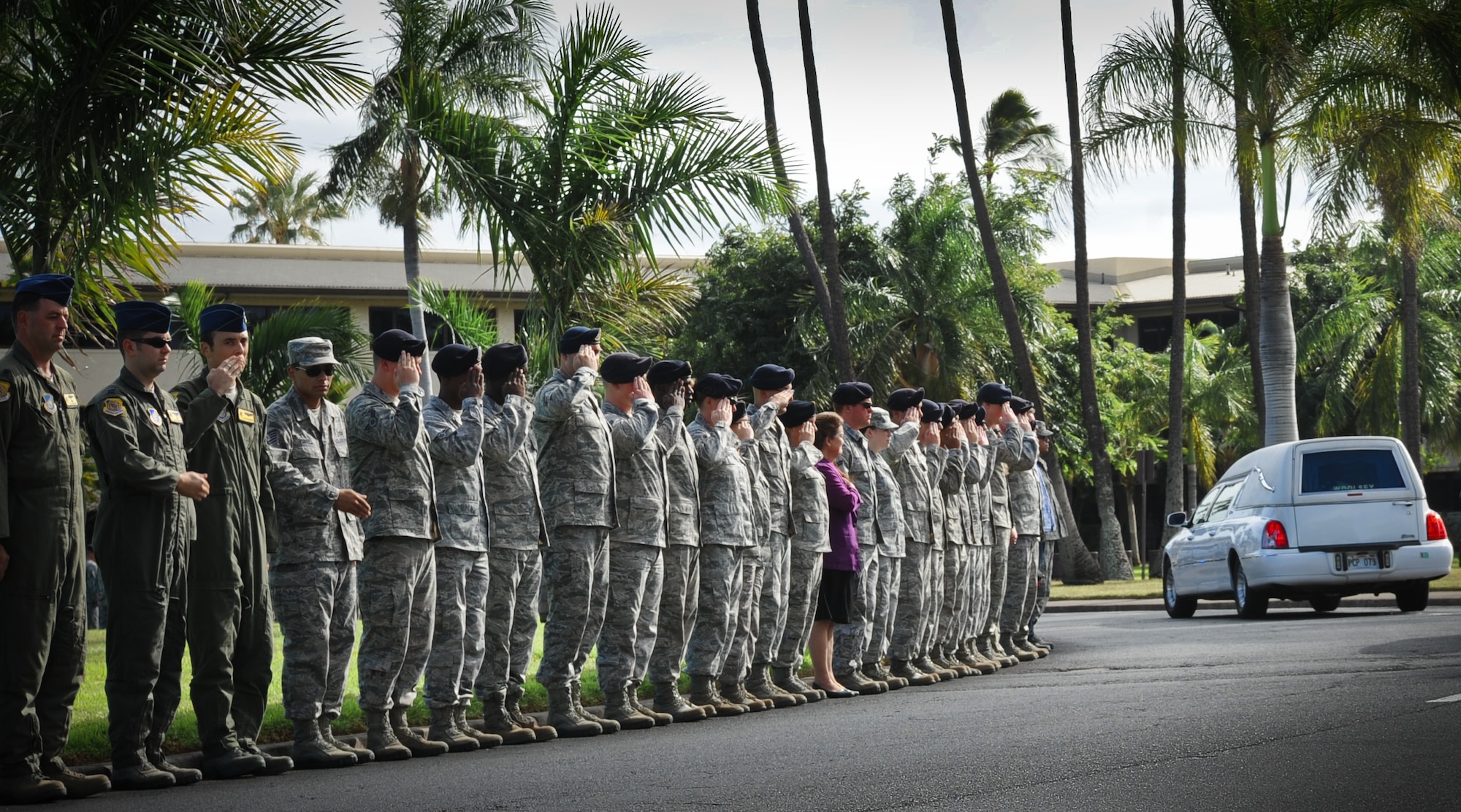 Airmen line Atterbury Circle on Joint Base Pearl Harbor-Hickam to salute and pay their respects as the remains of Wilfred "Fred" Toczko, a retired Army captain and Hickam Field Survivor, pass by, Jan. 11. Toczko was assigned to the 72nd Bombardment Squadron during his time at Hickam Field. He later attended flight school and learned to fly the B-24 Liberator Bomber. During a bombing mission over Germany, he was shot down and held as a Prisoner of War until the war ended in 1945. (U.S. Air Force photo/Senior Airman Lauren Main)