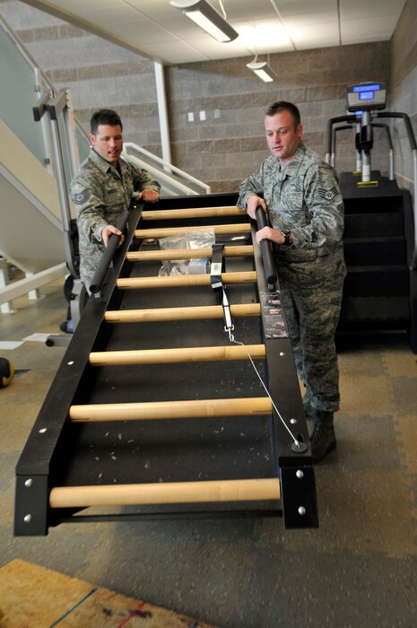 Tech. Sgt. Robert McFadden, 151st Air Refueling Wing, and Staff Sgt. Seth Mayer, Utah Air National Guard recruiter, help set up a Jacobs Ladder in the base gym at the Utah ANG base in Salt Lake City, Utah, Jan. 11, 2012. McFadden and Mayer are part of a team in charge of moving the gym equipment from the old base gym to the new location in the new fire station building on the base.  (U.S. Air Force Photo by Tech. Sgt. Jeremy Giacoletto-Stegall/Released)