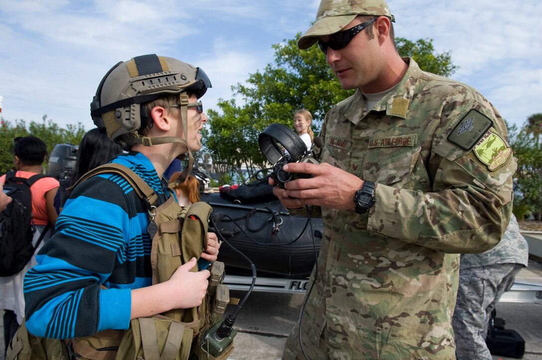 Pararescueman Staff Sgt. Matt Williams fits a headset for a boy at the 308th Rescue Squadron demonstration Jan. 7, 2012, at Patrick Air Force Base, Fla. Reservists of the 920th Rescue Wing provided key support for Patrick's second Saturday’s Kids Understanding Deployment Operations event. (U.S. Air Force photo/Julie Dayringer)