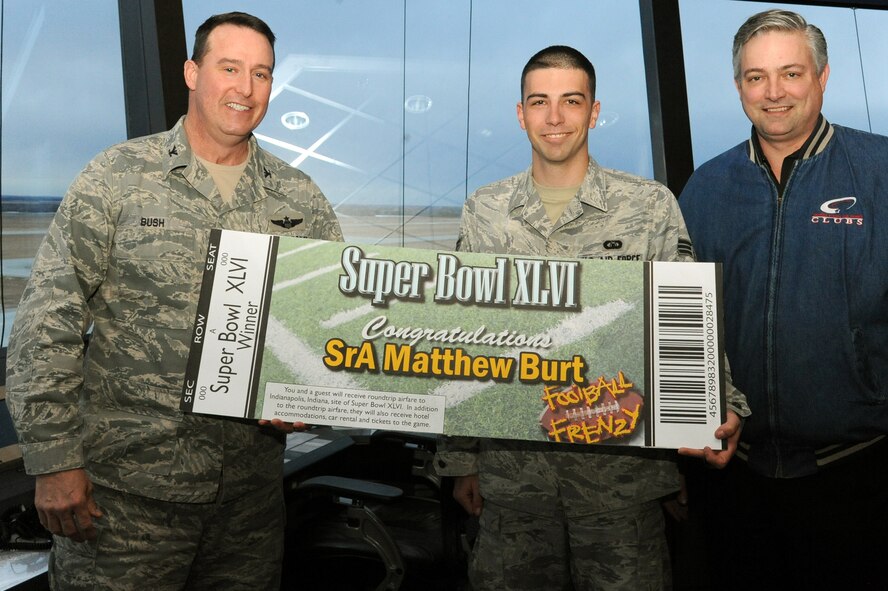 Col. Timothy Bush, 319th Air Base Wing commander, and Richard Howard, Northern Lights Club manager, present Senior Airman Matthew Burt, 319th Operations Support Squadron, with tickets to Super Bowl XLVI after being drawn as the winner of the Air Mobility Command portion of the Air Force-wide “Football Frenzy” contest Jan. 10 on Grand Forks Air Force Base, N.D.  The prize includes a four-day all-expenses paid trip and tickets to Indianapolis, Ind., for this year’s Super Bowl. (U.S. Air Force photo by Airman 1st Class Xavier Navarro)