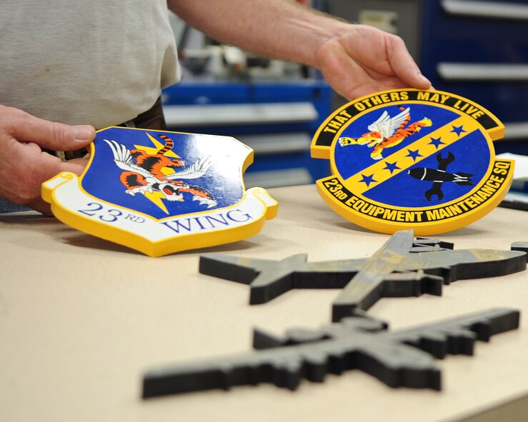 James Connelly, 23rd Force Support Squadron master craftsman, displays wooden replicas of 23rd Wing and the 23rd Equipment Maintenance Squadron patches at Moody Air Force Base, Ga., Jan. 11, 2012. Craftsmen at the Arts and Crafts Center’s wood shop create a variety of jobs including retirement boxes, squadron projects and more, not only for Moody members, but also retirees and those from other bases. (U.S. Air Force photo by Airman Olivia Dominique/Released) 
