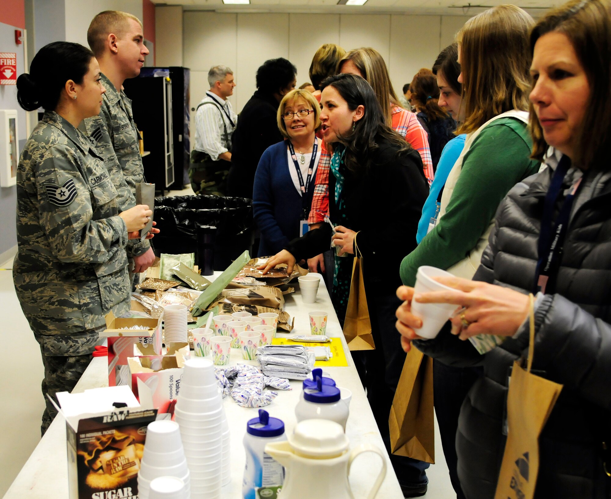U.S. Air Force Tech. Sgt. Jennie Carmichael and Senior Airman David Solnok speak with educators about meals-ready-to-eat Jan. 6, 2012, Eielson Air Force Base, Alaska. During Operation Bug Out, Carmichael, 354th Medical Operations Squadron NCO in charge of Ambulatory Services, and Solnok, 354th Communications Squadron network infrastructure technician, provided educators from Eielson and nearby communities a sample of an MRE. (U.S. Air Force photo by Airman 1st Class Yash Rojas/Released)