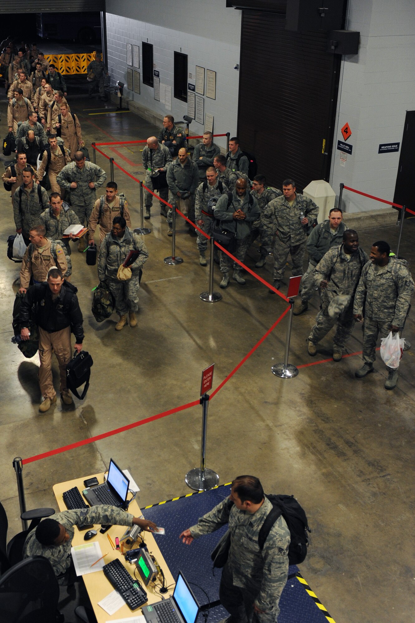 Team Dyess Members, and Team Little Members file through the processing line prior to departing for deployments, Jan. 10, 2012, at Little Rock Air Force  Base, Ark. Nearly 200 Airmen deployed to support combat operations in Southwest Asia. (U.S. Air Force Photo by Airman 1st Rusty Frank)