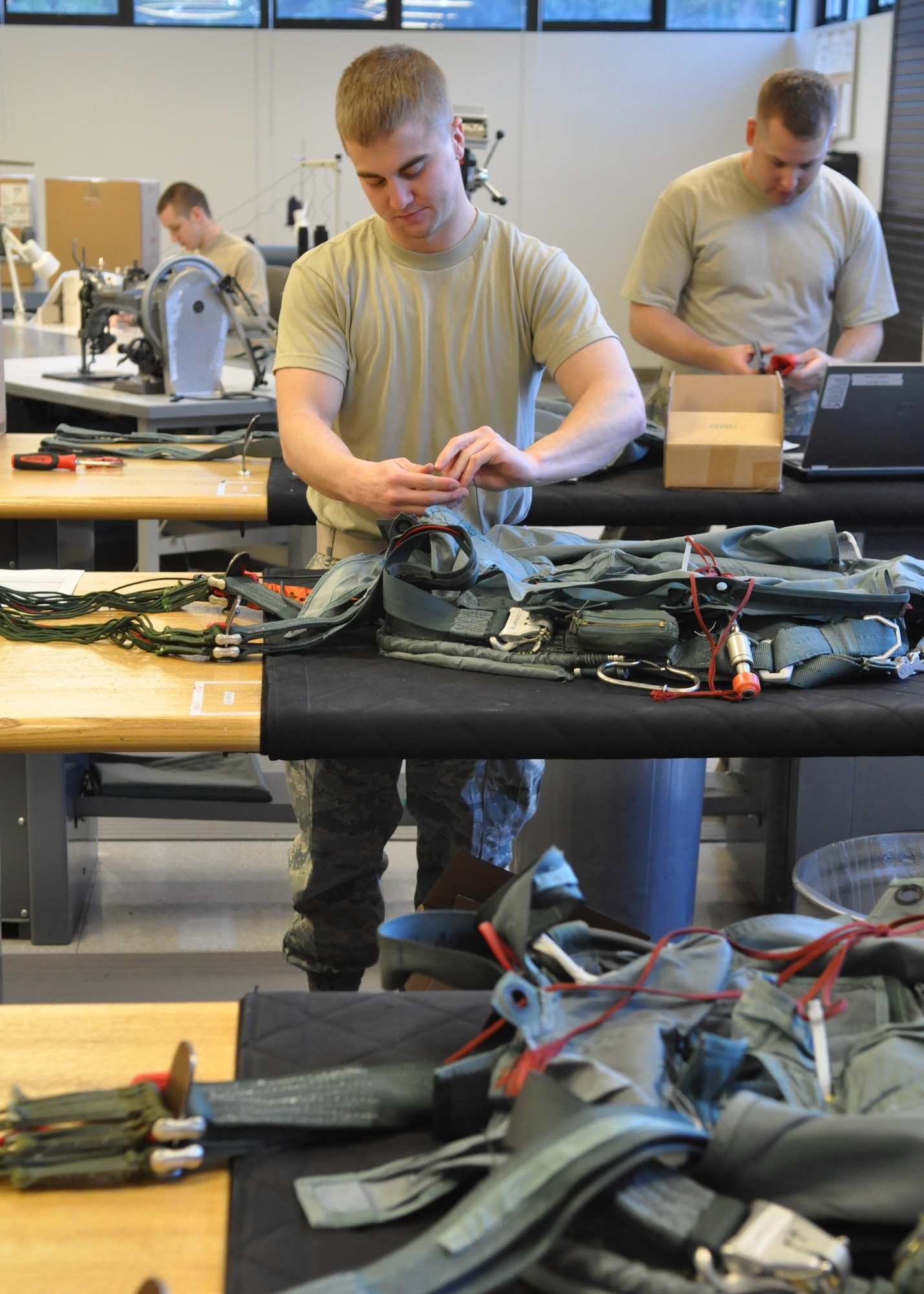 Airmen assigned to the 62nd Operations Support Squadron aircrew flight equipment flight prepare equipment to be loaded rigged into parachutes Jan. 11, 2012, at Joint Base Lewis-McChord, Wash. The flight is responsible for tasks such as rigging parachutes, packing life rafts and ensuring all emergency equipment is current. (U.S. Air Force photo/Airman 1st Class Leah Young)