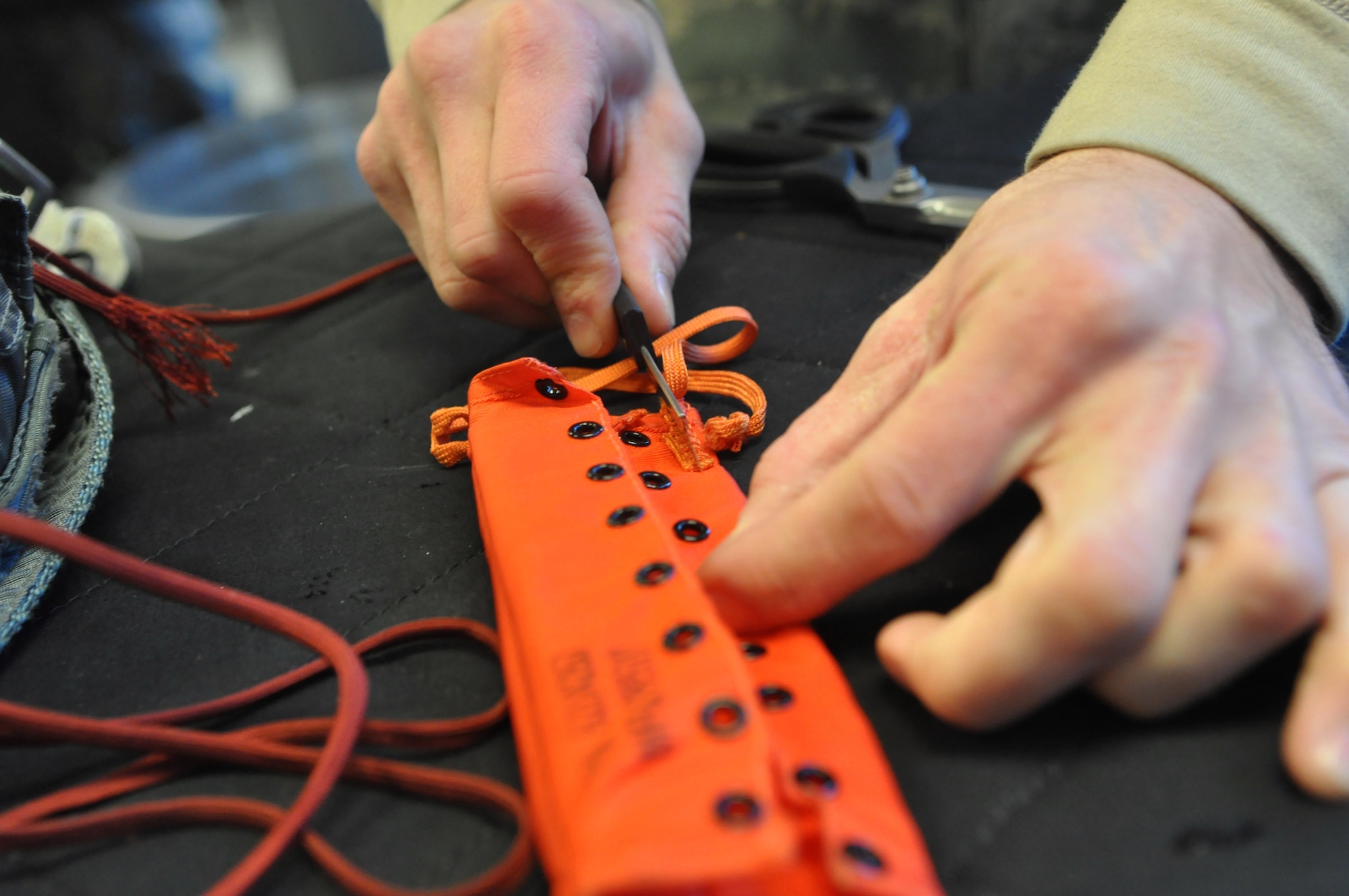 Airman 1st Class David Prylo, 62nd Operations Support Squadron aircrew flight equipment technician, prepares equipment to be loaded rigged into a parachute Jan. 11, 2012, at Joint Base Lewis-McChord, Wash. As part of the 62nd OSS, the aircrew flight equipment flight is responsible for maximizing each aircrew member's performance while protecting and sustaining human life during flight operations. (U.S. Air Force photo/Airman 1st Class Leah Young)