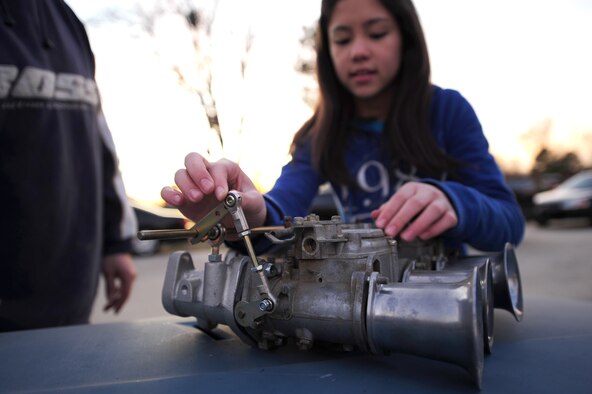 Alicia Stanton, 12, attaches a throttle linkage to a carburetor at her home in Goldsboro, N.C., Jan. 5, 2012. Since she was three years old Alicia has worked with her father, Master Sgt. Marty Stanton, 4th Logistics Readiness Squadron vehicle management superintendent, to fix and repair vehicles. (U.S. Air Force photo by Senior Airman Rae Perry)