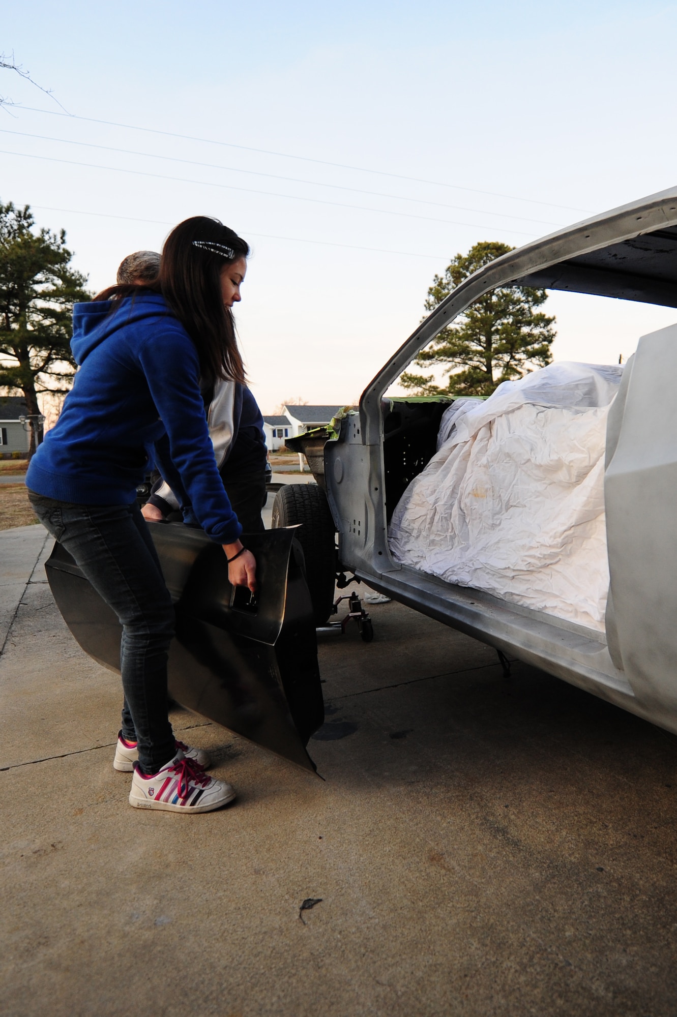 Alicia, 12, helps her father, Master Sgt. Marty Stanton, place a door onto a 1974 Dodge Challenger at their home in Goldsboro, N.C., Jan. 5, 2012. Stanton has worked on cars since taking a vocational class at his high school and will continue to restore them well into the future. Stanton is a 4th Logistics Readiness Squadron vehicle management superintendent. (U.S. Air Force photo by Senior Airman Rae Perry)