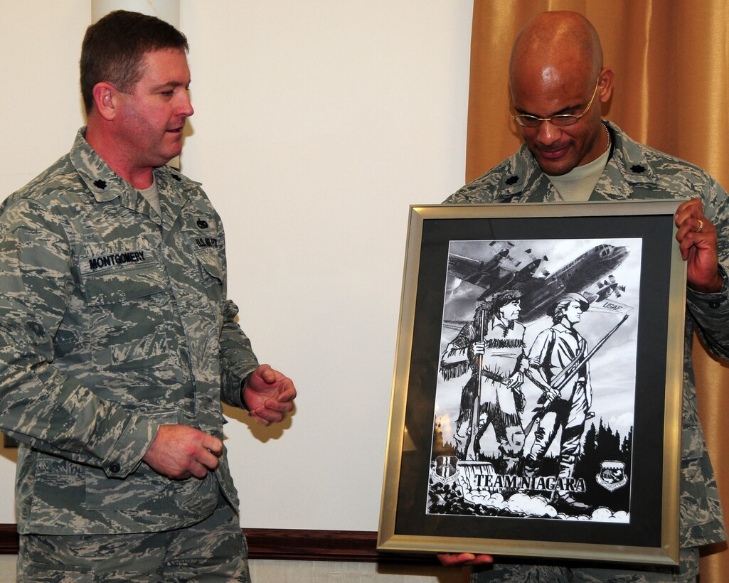 Lt. Col. Miles Montgomery (left), 914th Maintenance Group deputy commander, presents Lt. Col. Kelvin McElroy, 914th Maintenance Group commander, a drawing representing the association of the 914 and 107 Airlift Wings during a farewell luncheon in McElroy's honor on January 5, 2012. McElroy has been the Maintenance Group commander since July of 2009. His new assignment will take him to Dover Air Force Base, Delaware. (U.S. Air Force photo by Peter Borys)