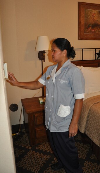 LAUGHLIN AIR FORCE BASE, Texas— Luzcilyn Budd, Laughlin Manor housekeeper, ensures a thermostat is set appropriately before leaving a guest's room. The manor's initiative to conserve energy for the Air Force by setting thermostats and turning off appliances and lights saves 19,275 kilowatt hours per year. (U.S. Air Force photo/2nd Lt. James Ramirez)