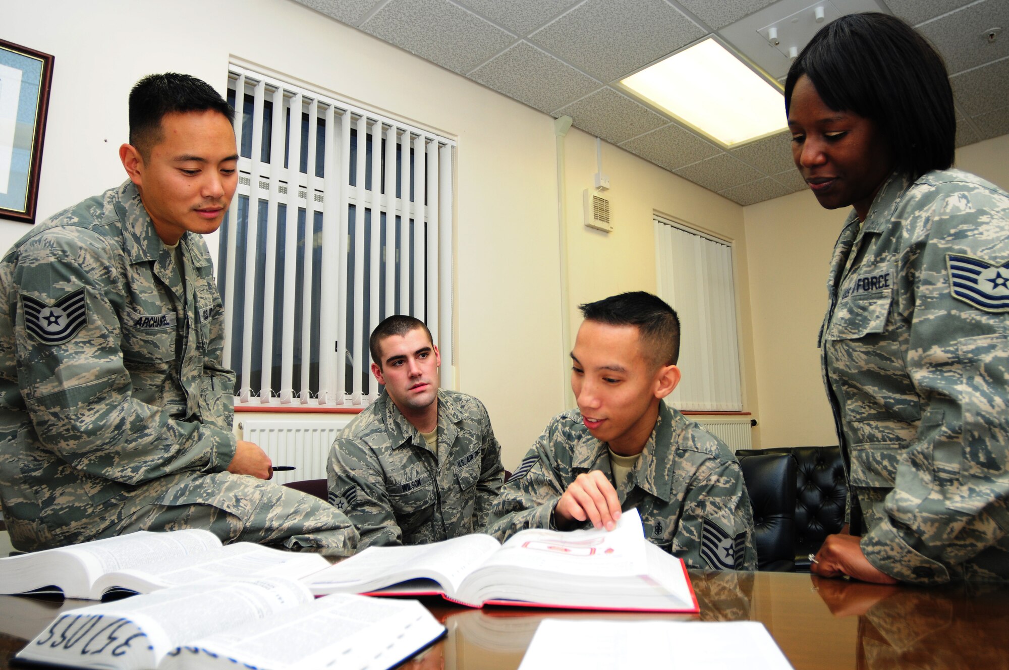 ROYAL AIR FORCE MILDENHALL, England -- Tech. Sgt. Neil Paule, 48th Aeromedical Squadron aeromedical service craftsman, reviews medical study material with co-workers, Jan. 9, 2012. Paule was submitted by one of his co-workers as being an exceptional Wingman for his dedication to helping fellow Airmen.  (U.S. Air Force photo by Senior Airman Lausanne Morgan)