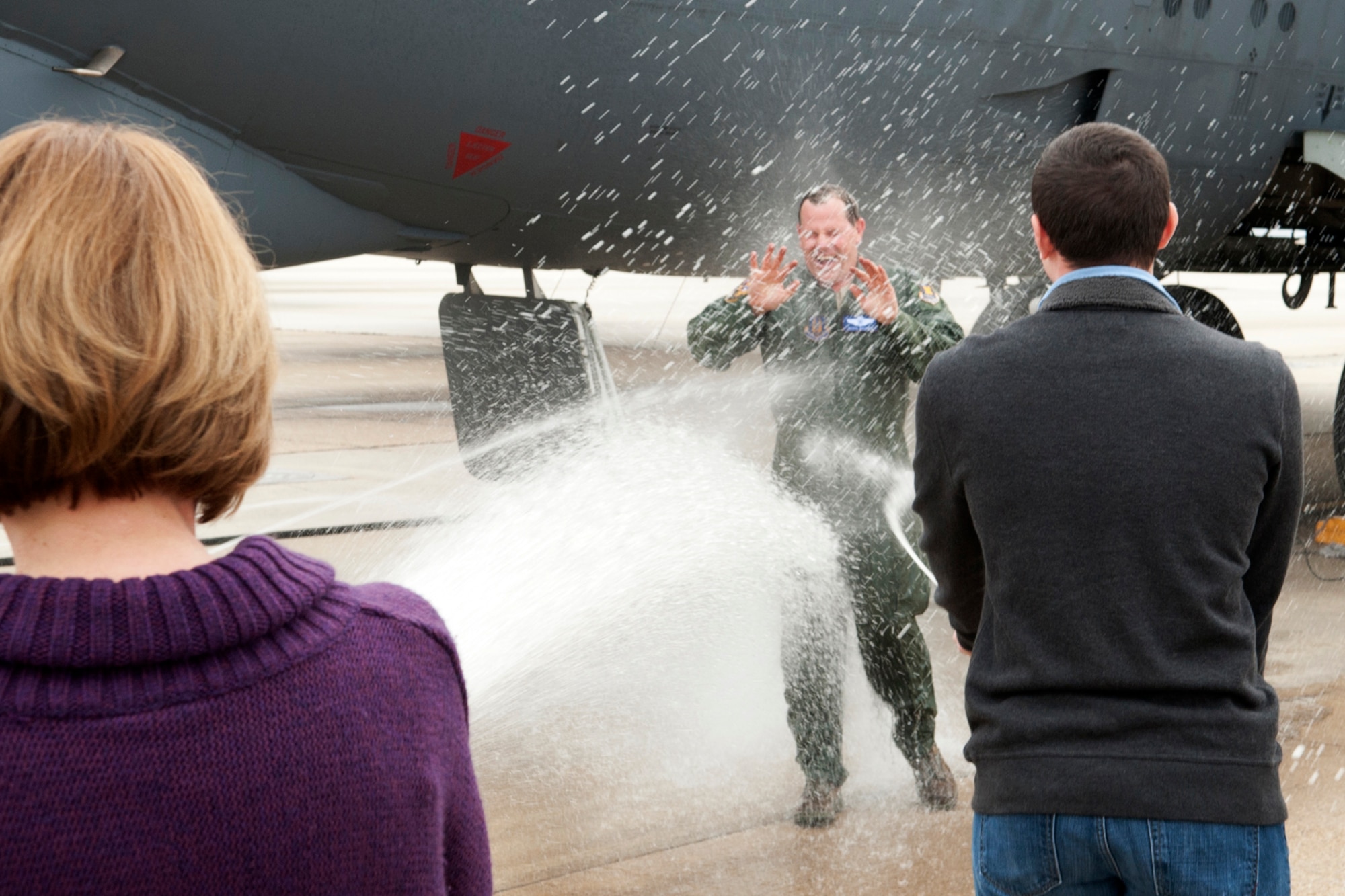 Linda and Matt Rounds, wife and son of U.S. Air Force Lt. Col. Chris Rounds, sprays him down after his return from a B-52 mission, Barksdale Air Force Base, La., Jan. 8, 2012. Rounds is retiring from the Air Force Reserve with over 5,800 flying hours in the B-52. (U.S. Air Force photo by Master Sgt. Greg Steele/Released)