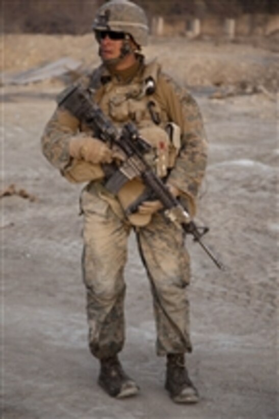 Petty Officer Jack P. Harris, assigned to Kilo Company, 3rd Battalion, 7th Marine Regiment, Regimental Combat Team 8, scans the area during a security patrol in Sangin, Afghanistan, on Dec 15. 2011. 