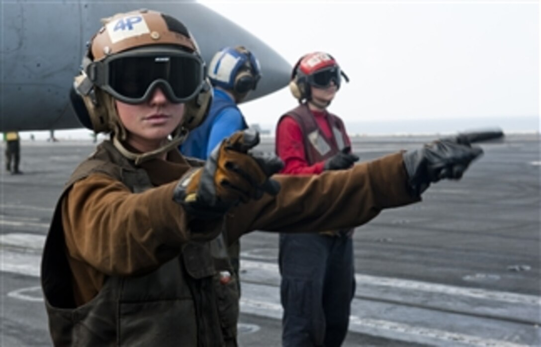 U.S. Navy Airman Elaine Ketola (left) signals for the start up of an F/A-18C Hornet aircraft from Strike Fighter Squadron 192 on the flight deck of the aircraft carrier USS John C. Stennis (CVN 74) in the Arabian Sea on Jan. 9, 2012.  The Stennis is deployed to the U.S. 5th Fleet area of responsibility to conduct maritime security operations and support missions as part of Operation Enduring Freedom.  