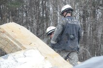 Army Staff Sgt. John Cogley, Squad Leader for the 911th TREC 2nd Platoon, First Squad, wearing protective sunglasses, instructs a junior Soldier atop a rubble pile during joint training with Marines from the Chemical Biological Incident Response Force’s Technical Rescue Platoon at the Downey Responder Training Facility onboard the Naval Support Facility Indian Head Stump Neck Annex, 10 - 12 Jan, 2012.