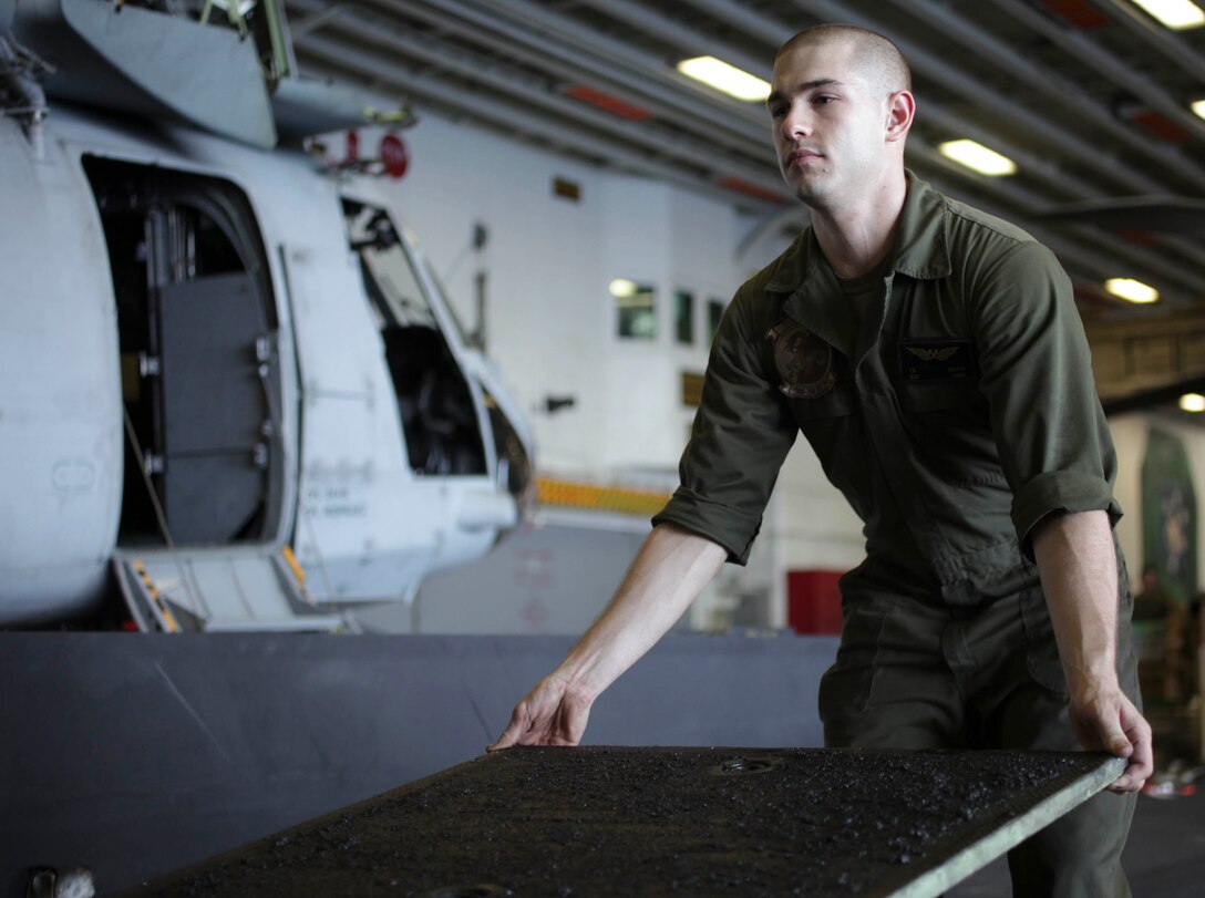 Sgt. Timothy Bierce, a 22-year-old Litchfield, Conn., native, moves a CH-46E Sea Knight floor panel aboard USS Makin Island (LHD 8) here Jan. 11. Bierce serves as an air-frame mechanic with Marine Medium Helicopter Squadron 268 (Reinforced), the aviation combat element for the 11th Marine Expeditionary Unit. The unit is currently deployed aboard the amphibious assault ship as part of the Makin Island Amphibious Ready Group (MKIARG), which is a U.S. Central Command theater reserve force. The group is also providing support for maritime security operations and theater security cooperation efforts in the U.S. 5th Fleet area of responsibility.