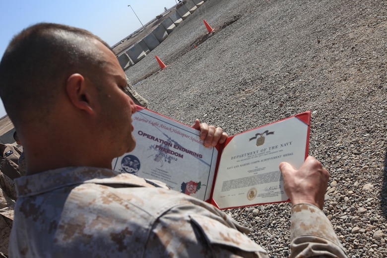 Sgt. Maj. Michael E. Golden, sergeant major of Marine Light Attack Helicopter Squadron 369, reads the award citation for Sgt. Christopher at Camp Bastion, Afghanistan, Jan. 12. Lemke, a mechanic with the squadron, and a native of Macomb, Mich., discovered a previously unknown issue with the UH-1Y Huey helicopter that represented an extreme risk to the aircraft and aircrew. The Marine was awarded the Navy and Marine Corps Achievement Medal for his potentially lifesaving find.