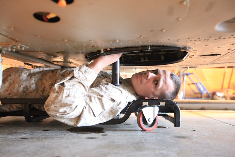 Sgt. Christopher Lemke, a mechanic with Marine Light Attack Helicopter Squadron 369, and a native of Macomb, Mich., looks into the “hell hole” underneath a UH-1Y Huey helicopter at Camp Bastion, Afghanistan. Lemke discovered a previously unknown issue inside the tight space that represented an extreme risk to the aircraft and aircrew. The Marine was awarded the Navy and Marine Corps Achievement Medal for his potentially lifesaving find.