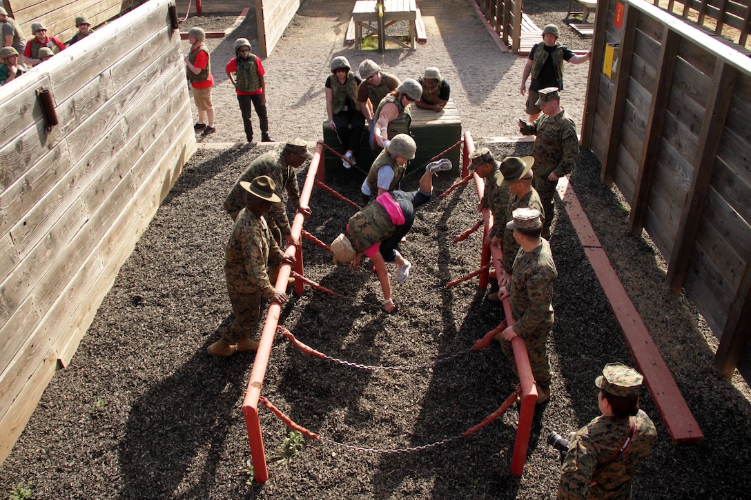 Marines watch as teachers work together to try and complete an obstacle Jan. 12 during the Recruiting Station Twin Cities 2012 Educators Workshop. The obstacle was one of several that recruits must complete at boot camp during the Crucible, a 54-hour exercise. For additional imagery from the event, visit www.facebook.com/rstwincities.