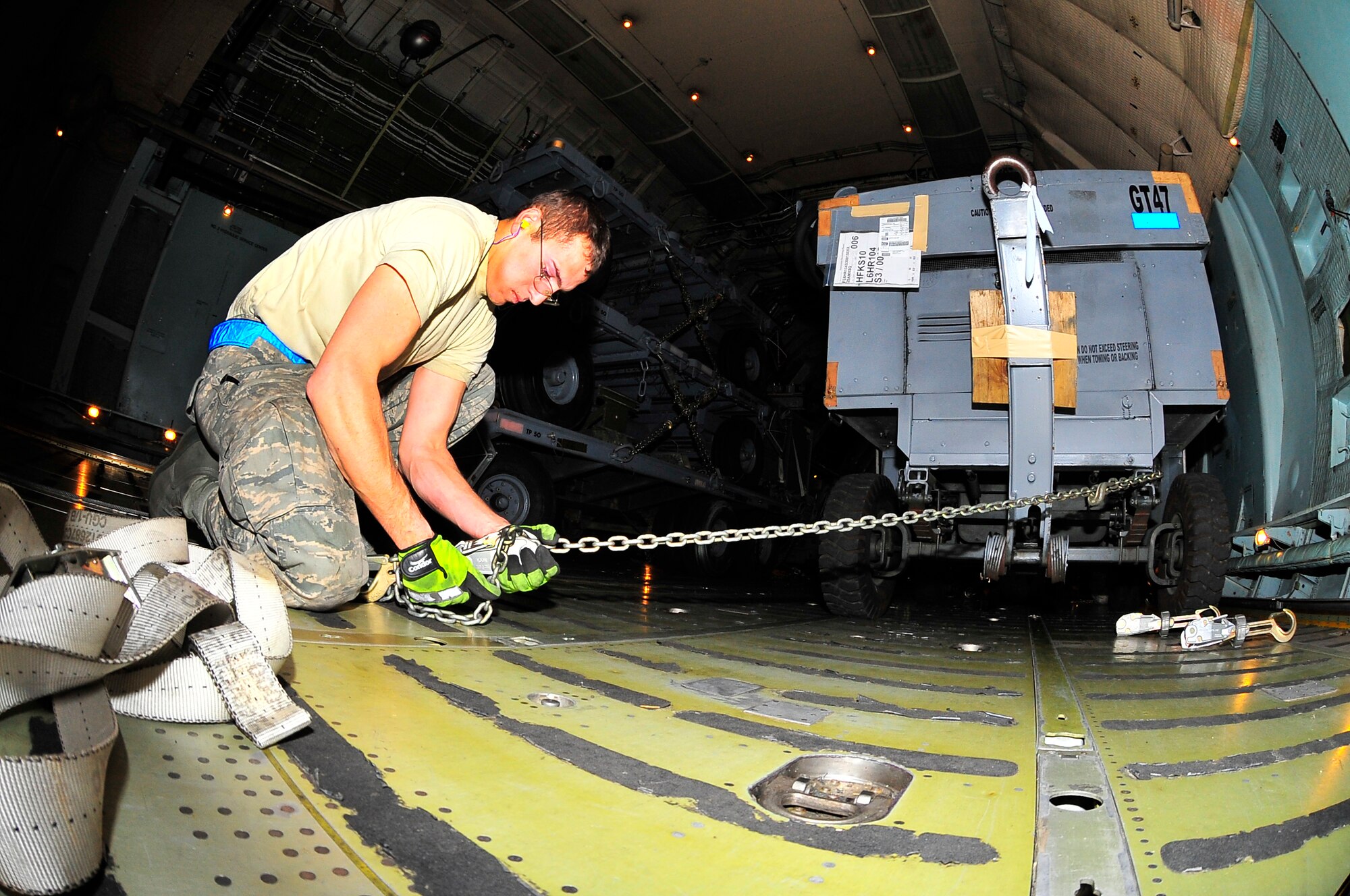 U.S. Air Force Senior Airman Justen Knighten, 20th Logistics Readiness Squadron deployment instructor, secures aerospace ground equipment inside a C-5 Galaxy, Jan. 6, 2012. Three C-5s landed at Shaw over a three day period to pick up Airmen and supplies in support of a deployment tasking being filled by Shaw Airmen. (U.S. Air Force Photo by Senior Airman Neil D. Warner/Released)