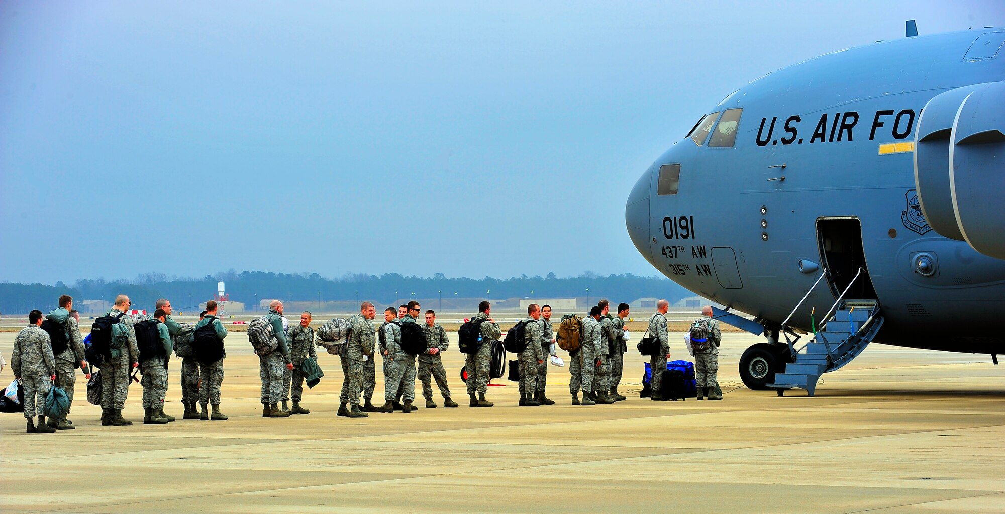 Members of the 55th Expeditionary Fighter Squadron file in line to began boarding a C-17 Globemaster, Jan. 10, 2012. Three C-5s and a C-17 landed at Shaw Air Force Base S.C., over a three-day period to pick up approximately 250 Airmen and supplies in support of a deployment tasking to Kunsan Air Base in Republic of Korea. (U.S. Air Force Photo by Senior Airman Neil D. Warner/Released) 