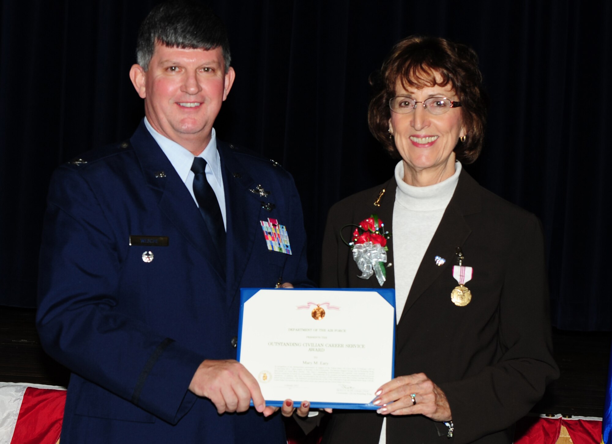 Retired Col. Richard L. Wesche, former 22nd Mission Support Group commander, presents Mary Eary, 22nd MSG secretary, with the Outstanding Civilian Career Service Award at her retirement ceremony Jan. 6, 2012, McConnell Air Force Base, Kan. Eary retired after 54 years of Federal civil service. (U.S. Air Force photo/ Tech. Sgt. Mitchell Fuqua)