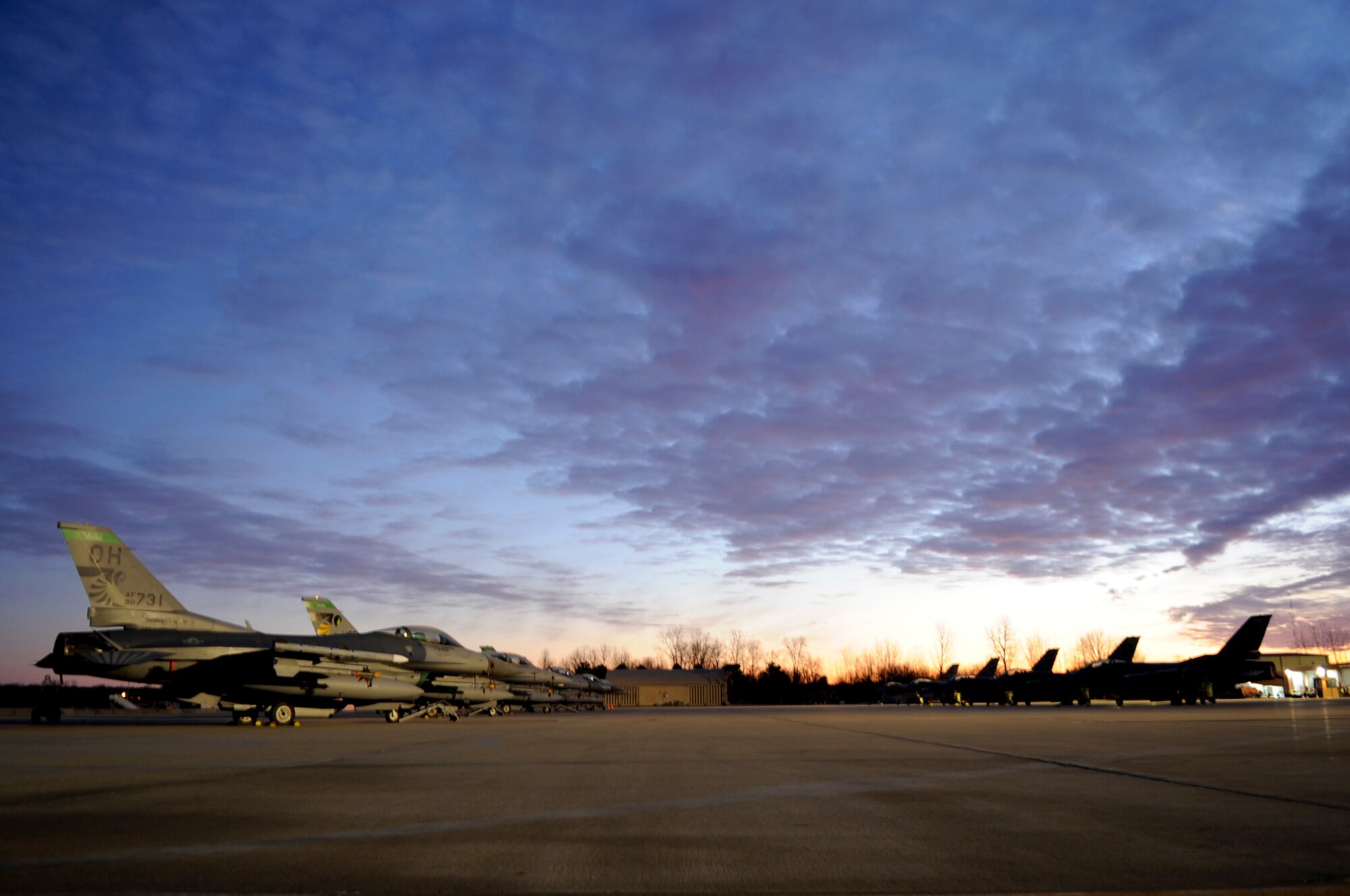 F-16CG aircraft silhouette the flightline in the early morning hours at the 180th Fighter Wing, Ohio Air National Guard, Swanton, Ohio. The 180th Fighter Wing performed a unit training assembly Jan. 7 and 8, 2012 where traditional status guardsmen participate in once monthly training activities such as flying and maintaining these aircraft.(U.S. Air Force photo by Master Sgt. Beth Holliker/Released)
