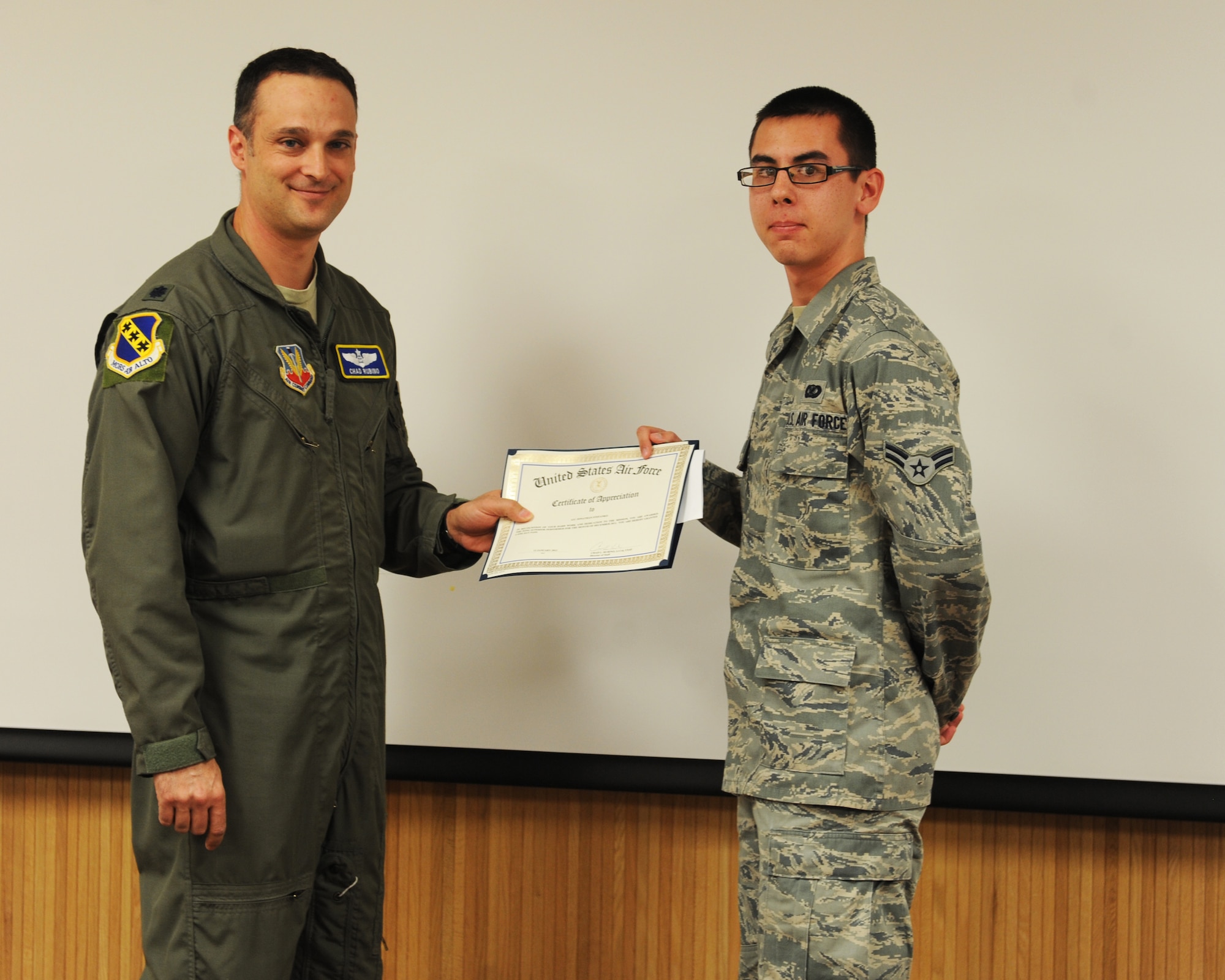 Lt. Col. Chad Rubino, 7th Bomb Wing director of staff, presents Airman 1st Class Jonathan Stefanko, 7 BW, with the January wing staff agencies superior performer award, Jan. 12, 2012, at Dyess Air Force Base, Texas. Every month each group selects one person or team who has shown superior performance to be recognized in front of wing leadership. (U.S. Air Force photo by Airman 1st Class Cierra Bullock/Released) 