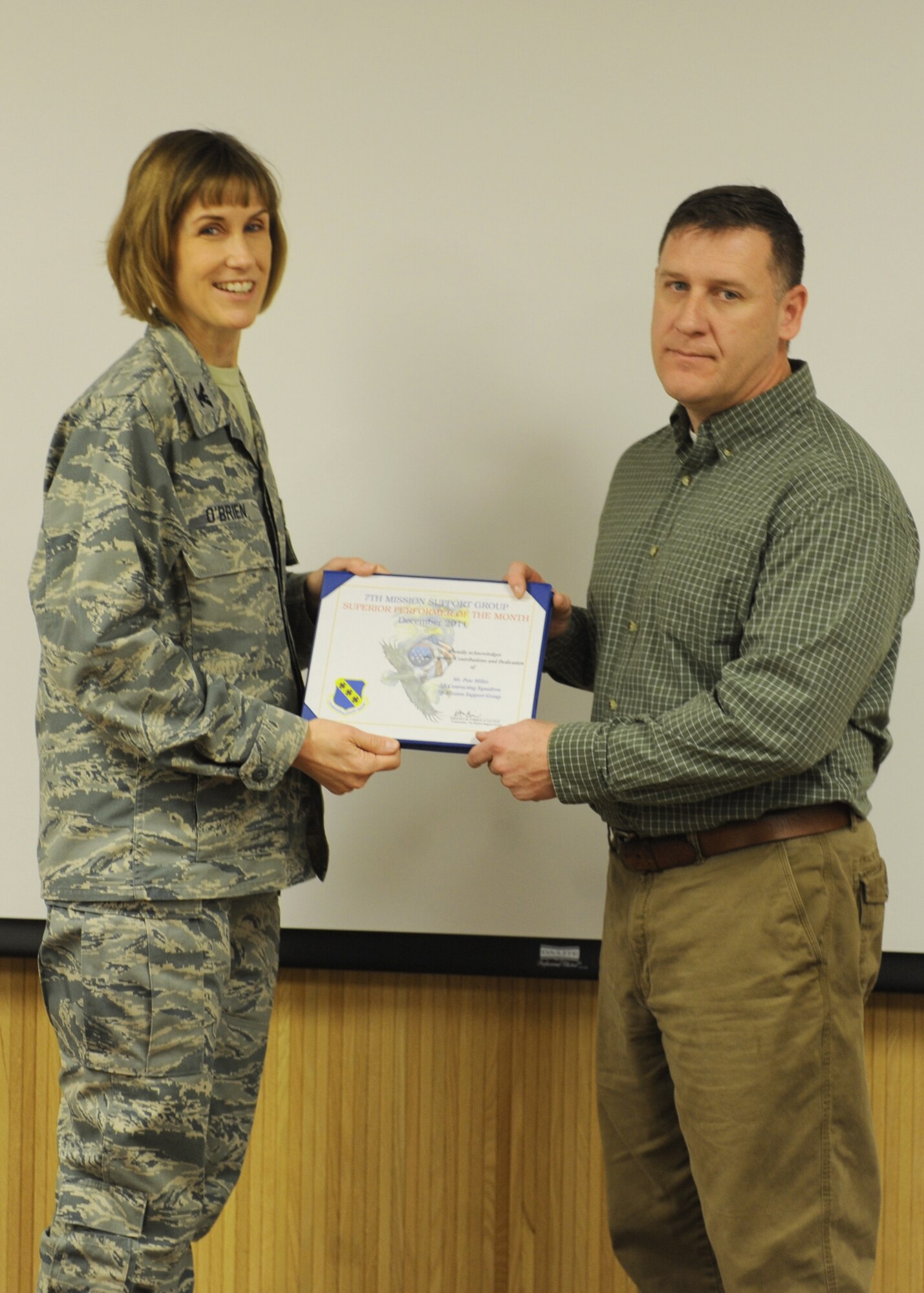 Col. Kristina O’Brien, 7th Mission Support Group commander, presents Pete Miller, 7 MSG, with the January 7 MSG superior performer award, Jan. 12, 2012, at Dyess Air Force Base, Texas. Every month each group selects one person or team who has shown superior performance to be recognized in front of wing leadership. (U.S. Air Force photo by Airman 1st Class Cierra Bullock/Released) 