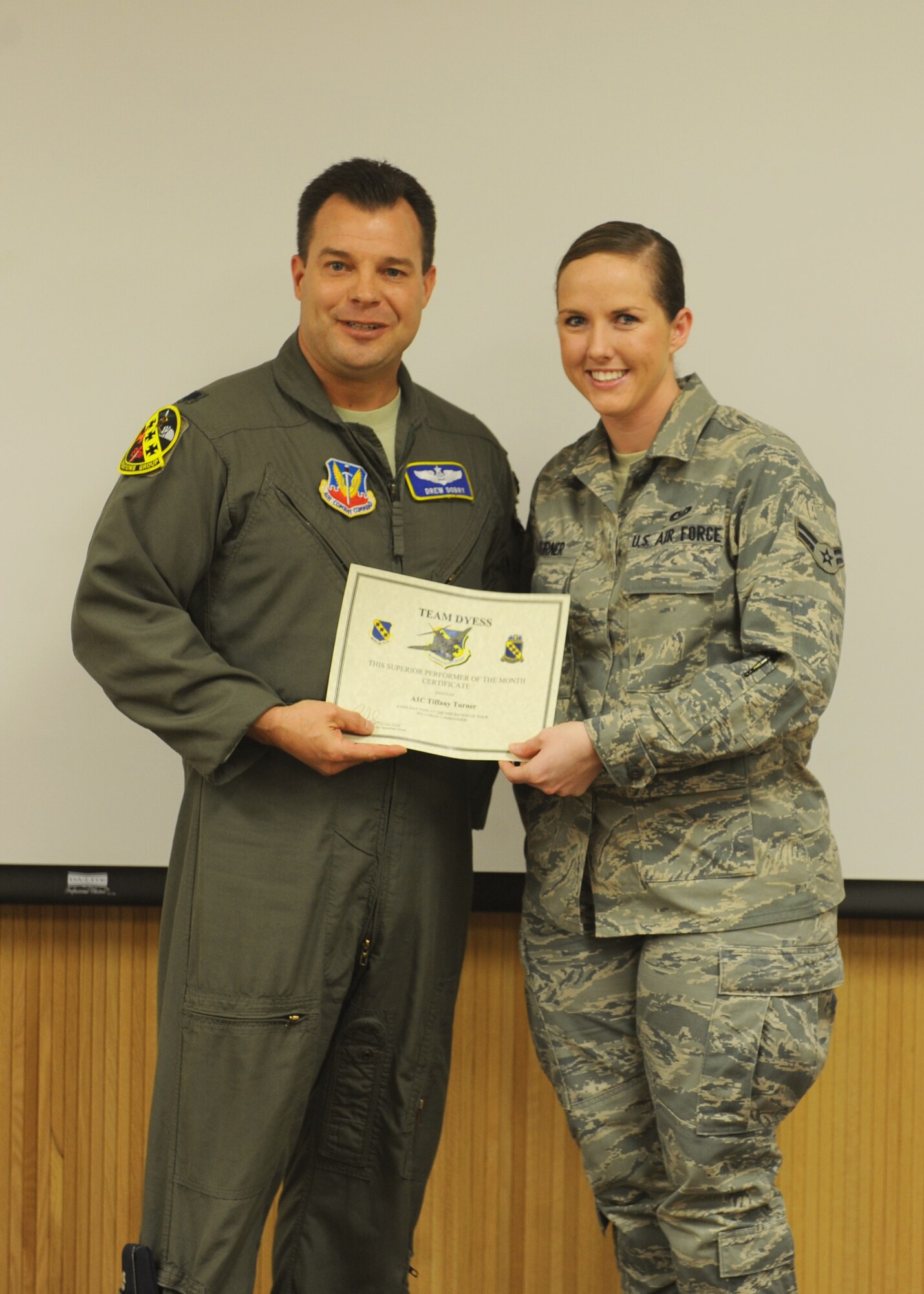 Lt. Col. Andrew Dobry, 7th Operations Group deputy commander, presents Airman 1st Class Tiffany Turner, 7 OG, with the January 7 OG superior performer award, Jan. 12, 2012, at Dyess Air Force Base, Texas. Every month each group selects one person or team who has shown superior performance to be recognized in front of wing leadership. (U.S. Air Force photo by Airman 1st Class Cierra Bullock/Released) 