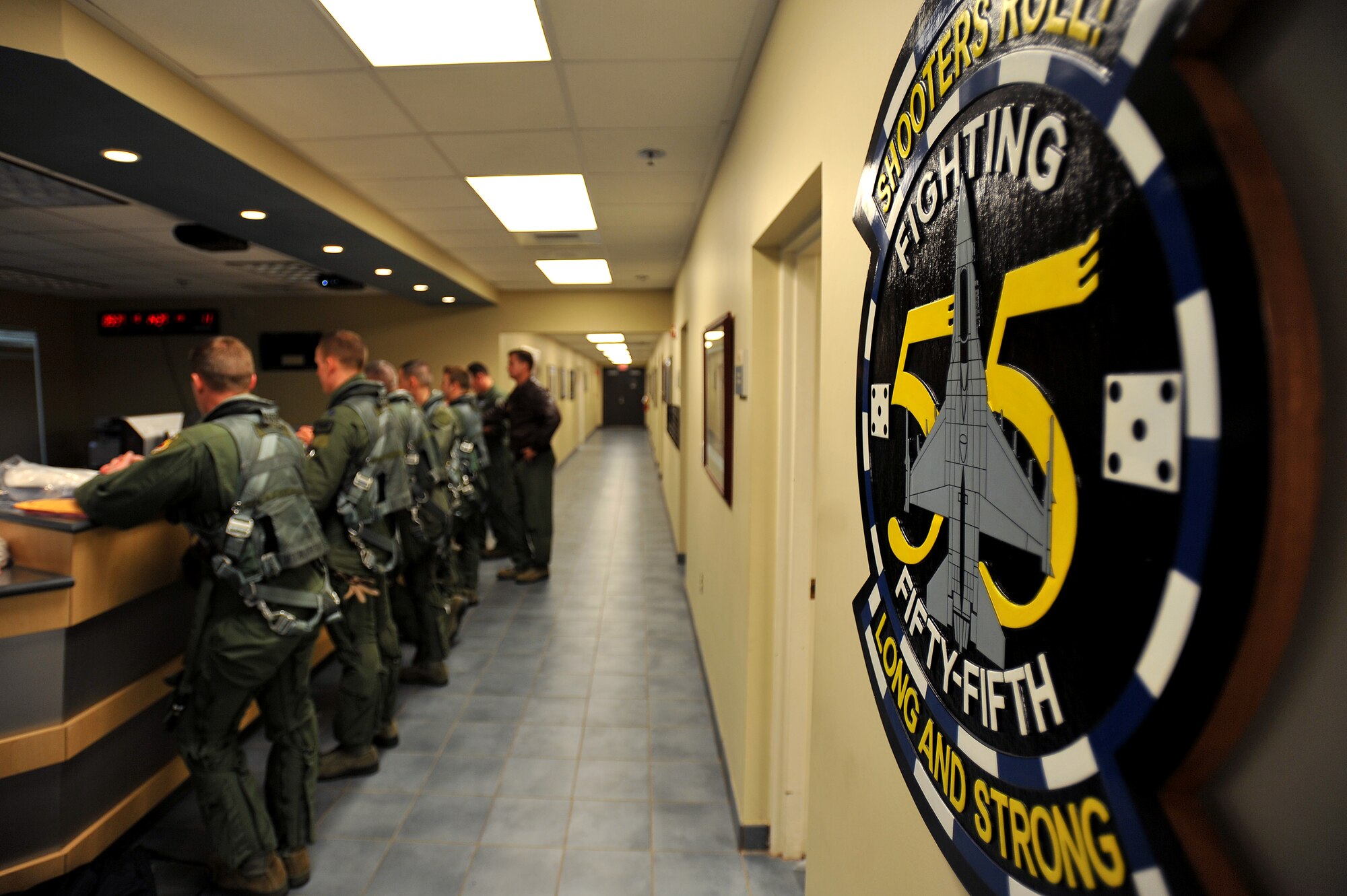 The 55th Fighter Squadron patch is displayed as symbol of pride in their building, as they do a preflight brief before stepping to their jets, Jan. 10, 2012, Shaw Air Force Base, S.C. Twelve F-16 aircraft and approximately 250 Airmen deployed to Kunsan Air Base, South Korea for a three-month deployment. The Airmen were activated as the 55th Expeditionary Fighter Squadron. (U.S. Air Force photo by Senior Airman Kenny Holston/Released)