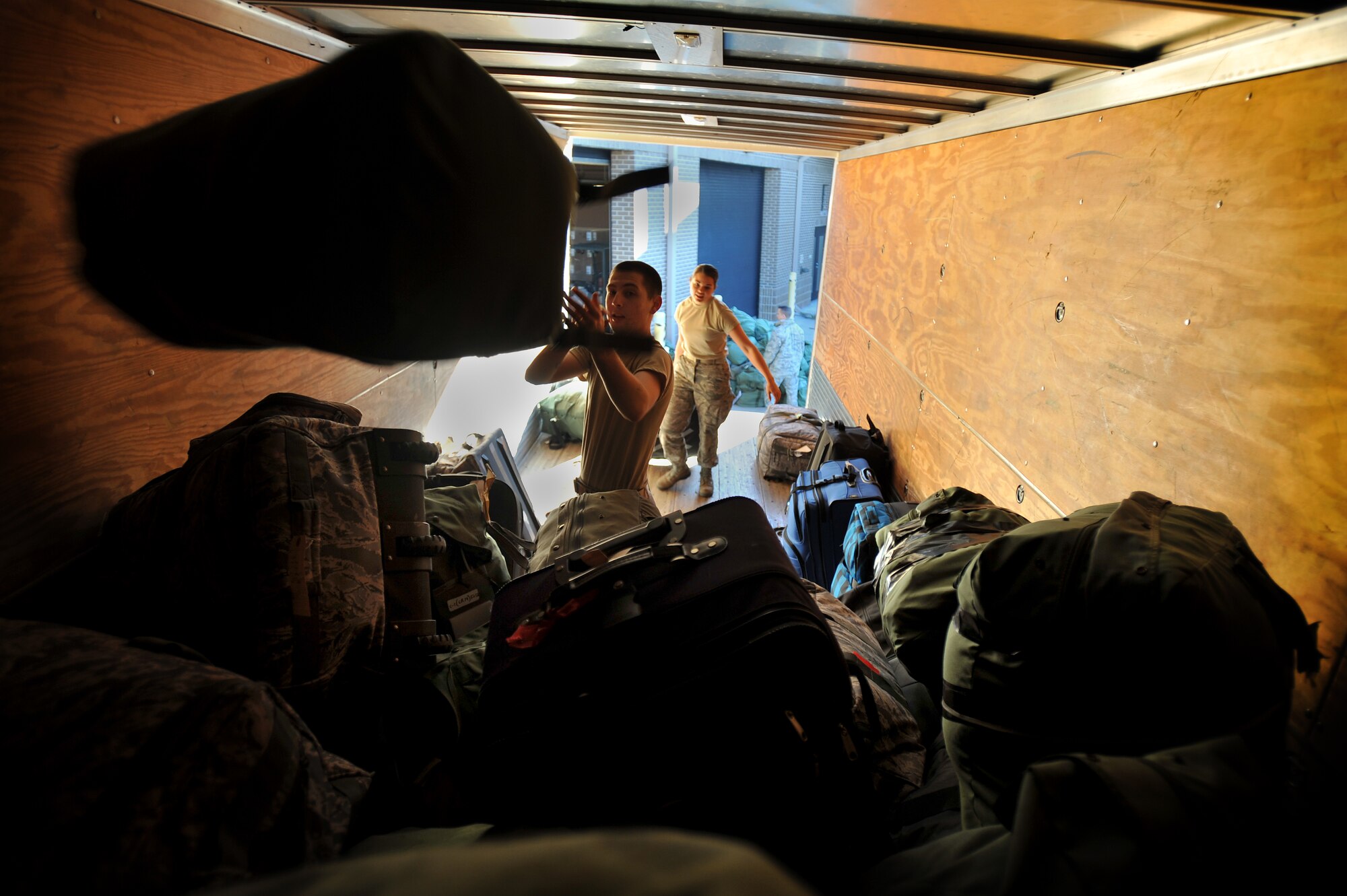 U.S. Air Force Airman 1st Class Justin Biser, 20th Maintenance Operations Squadron, tosses an Airman's mobility bag to the top of the pile as helps load bags into the back of a cargo truck, Jan. 6, 2012, Shaw Air Force Base, S.C. Biser helped provide mobility support to Airmen preparing to deploy to Kunsan Air Base in South Korea. He loaded more than 200 bags which were later transported to the Shaw flight line, palletized and loaded onto a C-5 Galaxy. (U.S. Air Force Photo by Senior Airman Kenny Holston/Released)


