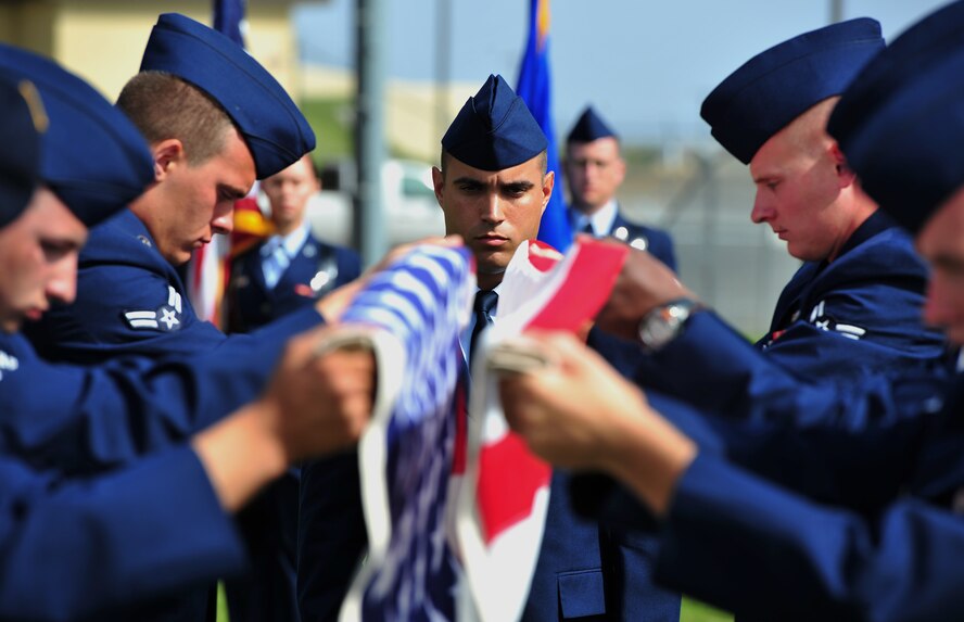 Airman 1st Class Kyle Cervi, Fairchild Air Force Base Honor Guard, leads the body bearer team as they fold the U.S. flag during a mock full-honors funeral ceremony at the Honor Guard graduation Sept. 15. (U.S. Air Force photo/Staff Sgt. Michael Means)
