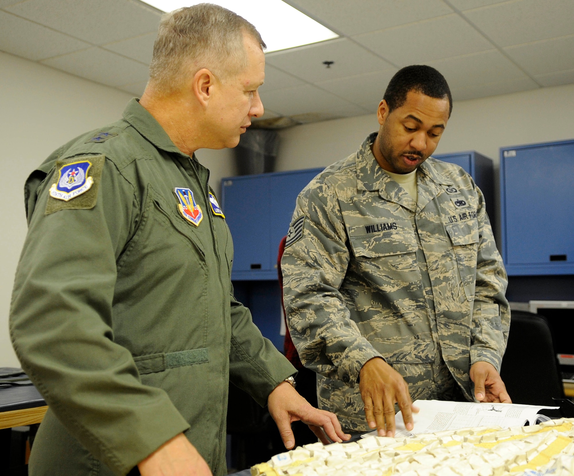 U.S. Air Force Maj. Gen. Lawrence Wells, 9th Air Force commander, reviews training documents with Tech. Sgt. Ralph Williams, 1st Operations Support Squadron NCOIC of aircrew flight equipment, during a visit to Langley Air Force Base, Va., Jan. 11, 2012. Wells visited Joint Base Langley-Eustis Jan. 9 through 11, and made stops at USAF Hospital Langley, the 633rd Air Base Wing and 1st Fighter Wing headquarters, and Fort Eustis’ Felker Army Airfield. (U.S. Air Force photo by Staff Sgt. Dana Hill/Released)