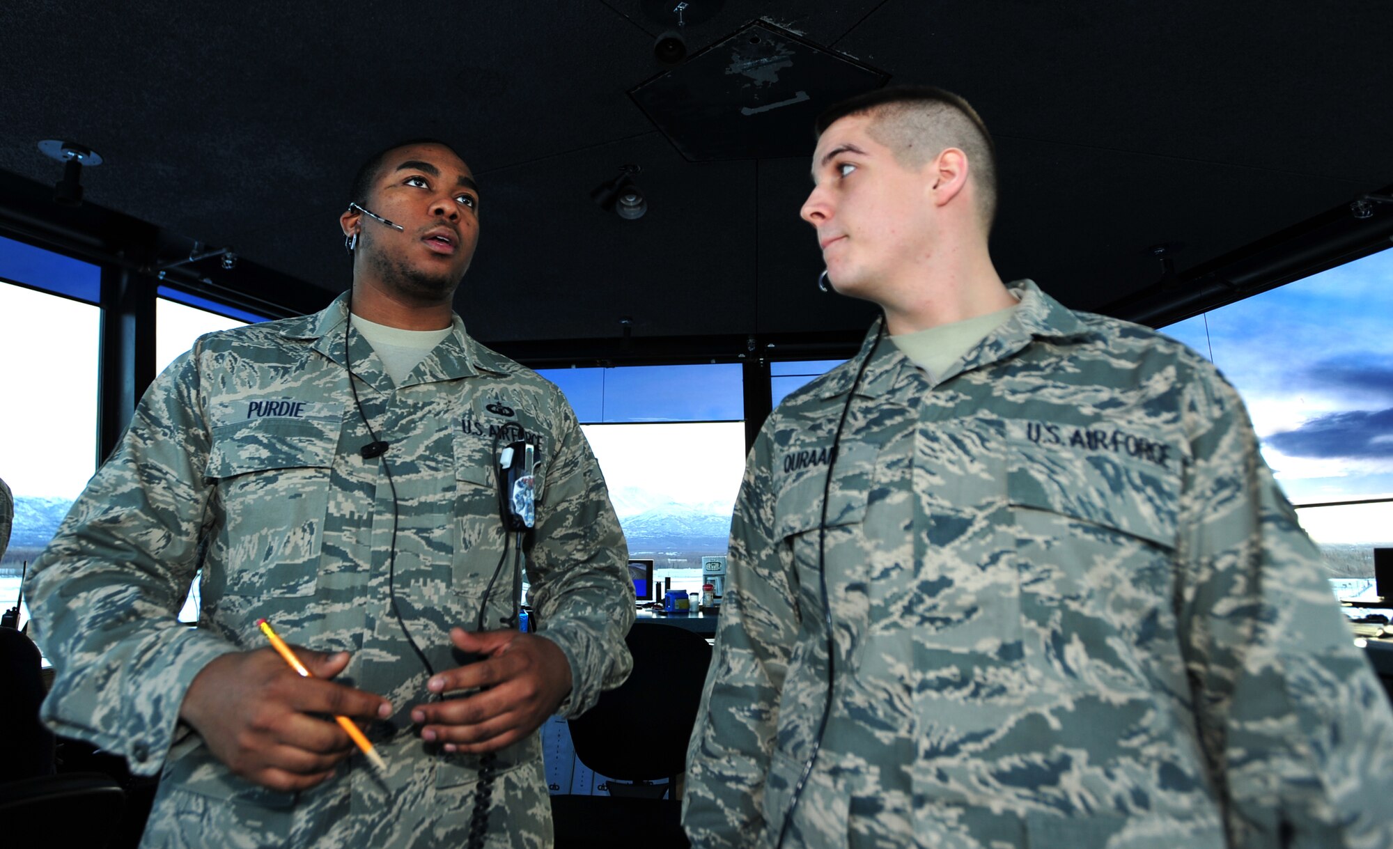 Staff Sgt. Rashade Purdie explains to Airman 1st Class Samer Quraan duties performed at the Air Traffic Control tower at Joint Base Elmendorf-Richardson, Alaska., Dec. 12, 2011. JBER's air traffic controllers handle an average of 150 flights daily to include directing the movement of aircraft into and out of the military airfields, relay flights and landing instructions, weather reports and safety informations to pilots. Purdie and Quraan are both assigned to the 3rd Operations Support Squadron. (U.S. Air Force photo/Staff Sgt. Sheila deVera)

 