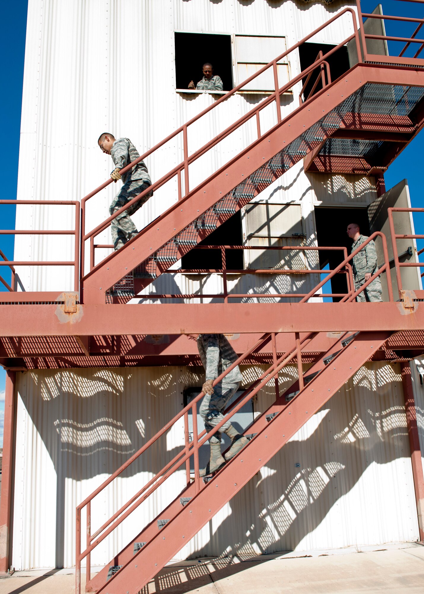 HOLLOMAN AIR FORCE BASE, N.M. -- U.S. Air Force Senior Airman Gabino Bejaran and U.S. Air Force Airman 1st Class Brandon Clark, both 49th Security Forces Squadron Special Reaction Team members, descend stairs Dec. 14, 2011, during a SRT tryout at the 49th Civil Engineer Squadron Firefighting training area. The SRT is a specialized team responsible for responding to high-risk situations within the base, including active shooter threats, barricaded suspects and hostage situation responses. (U.S. Air Force photo by Senior Airman Veronica Stamps/ Released)