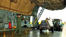 U.S. Air Force Tech. Sgt. Devin Paskewich, 436th Aircraft Maintenance Squadron crew chief, guides an incoming forklift with equipment on a C-5 Galaxy at Shaw Air Force Base S.C., Jan. 6, 2012. Paskewich worked with Shaw Airmen and other crew chiefs to load aerospace ground equipment and other cargo for transport overseas in support of a deployment tasking. (U.S. Air Force Photo by Senior Airman Neil D. Warner/Released)