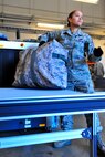 U.S. Air Force Airman 1st Class Ashley Mattison, 20th Maintenance Operations Squadron, handles baggage for deploying team members, Jan. 6, 2012. Three C-5s landed at Shaw Air Force Base S.C., over a three-day period to pick up Airmen and supplies in support of a deployment tasking. (U.S. Air Force Photo by Senior Airman Neil D. Warner/Released)