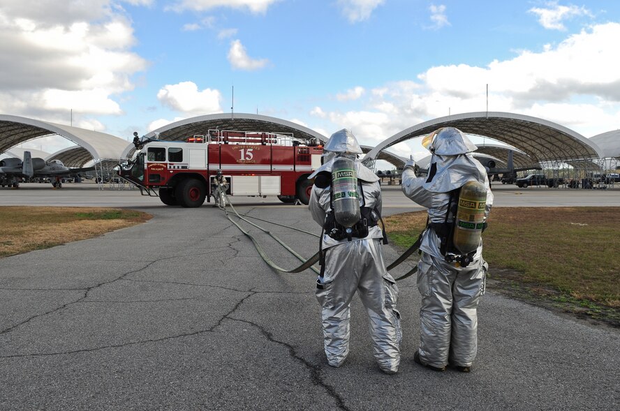 U.S. Air Force Airman 1st Class Zachary Lambert and Staff Sgt. Matthew Babbitt, 23rd Civil Engineer Squadron firefighters, gather a fire hose after responding to a simulated missile attack during a phase II operational readiness exercise at Moody Air Force Base, Ga., Jan. 11, 2012. The 23rd CES fire department is trained to be the first responders to emergencies of the highest priority. (U.S. Air Force photo by Airman 1st Class Olivia Dominique/Released)