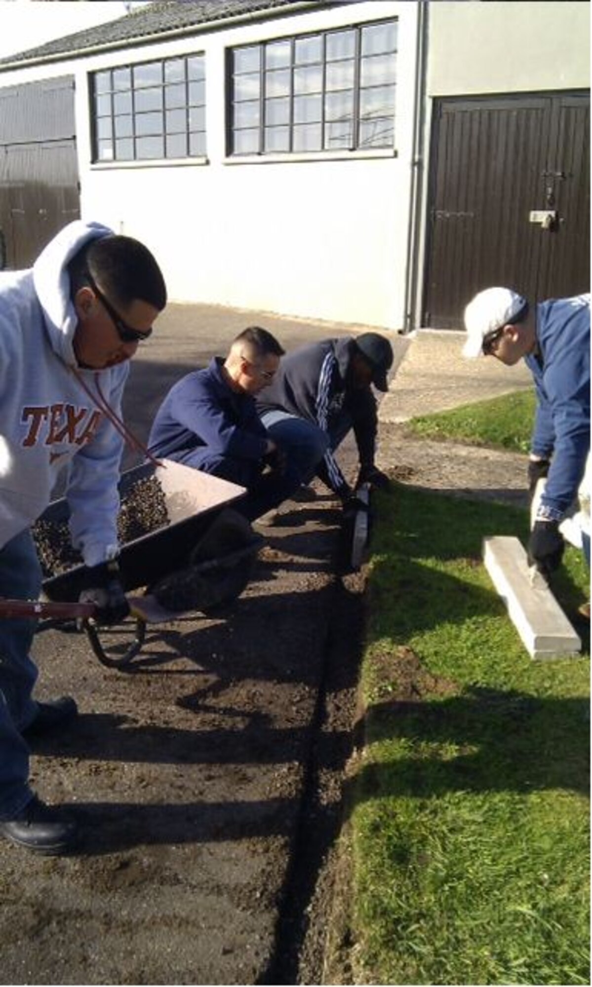 RAF MILDENHALL, England – Members from the 100th Civil Engineer Squadron Top-4, install a new curb at the 100th Bomb Group Memorial Museum, Thorpe Abbots, England, October 2011. The new curbs helped correct a three-decade-old drainage issue that had been plaguing the museum. (Courtesy photo) 