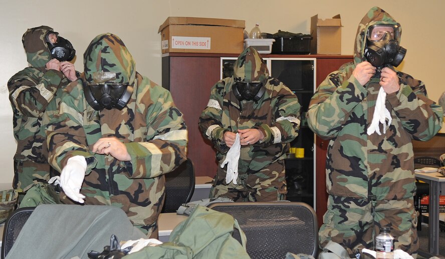 Airmen don their joint service light-weight integrated suits during a chemical, biological, radiological, nuclear and explosive class at Seymour Johnson Air Force Base, N.C., Jan. 9, 2012. The class instructors teach the Airmen how to properly put on their chemical gear within eight minutes. (U.S. Air Force photo/Senior Airman Gino Reyes)