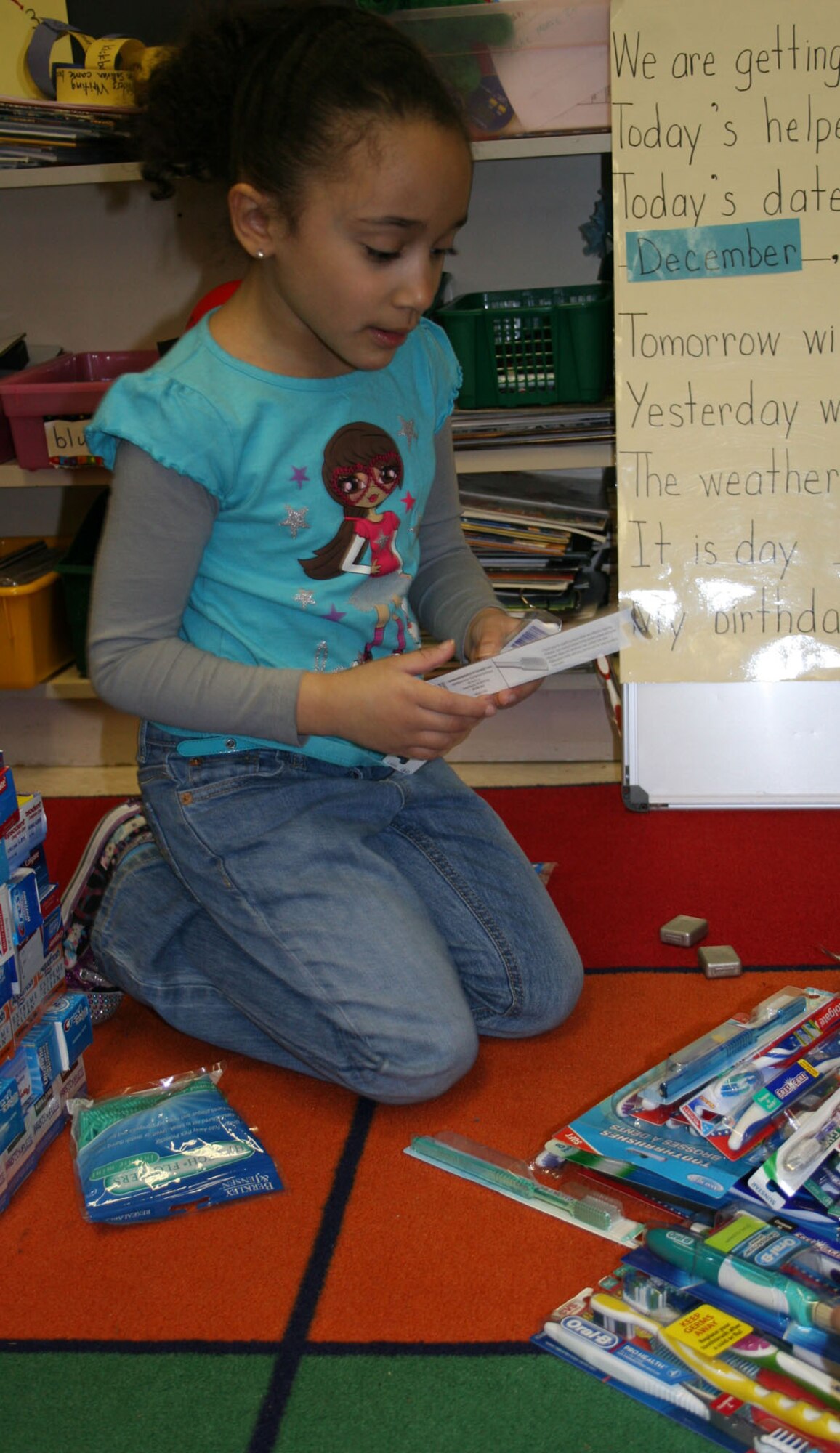 HANSCOM AIR FORCE BASE, Mass. - Genesis Sandoval sorts through toothbrushes to deliver to the local VA hospital just before the holidays. The Hanscom Primary School students and staff collected new clothing and personal hygiene items for the veterans as part of a lesson on “what it means to be a veteran.” First grade teacher Mary-Ann Sullivan has been organizing the donation drive for 15 years. The students also included hand-drawn cards for the veterans. (Courtesy photo)