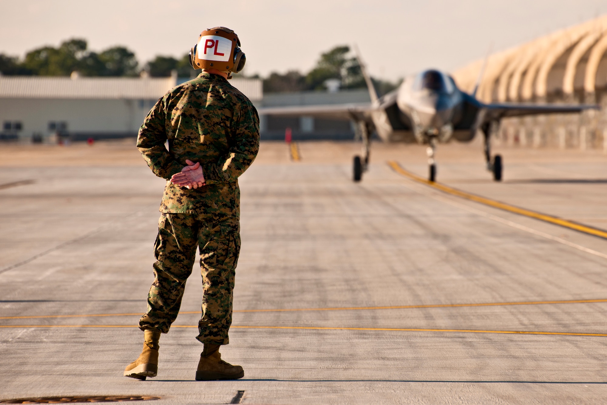 Gunnery Sgt. Matthew Smith, a maintainer with Marine Fighter Attack Squadron 501, watches as the first Marine variant F-35B Lightning II joint strike fighter roll toward him at Eglin Air Force Base, Fla., Jan. 11.  (U.S. Air Force photo/Samuel King Jr.)