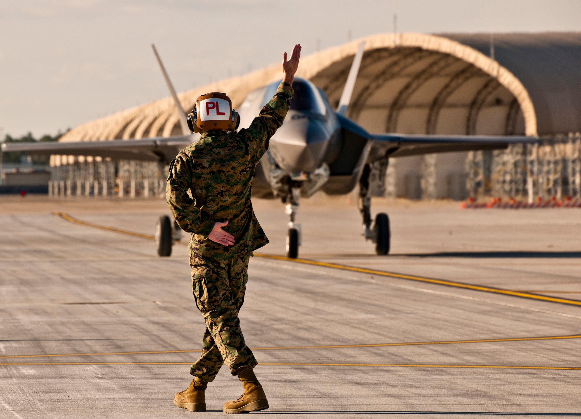 Gunnery Sgt. Matthew Smith, a maintainer with Marine Fighter Attack Squadron 501, marshals in the first Marine variant F-35B Lightning II joint strike fighter to arrive at Eglin Air Force Base, Fla., Jan. 11.  (U.S. Air Force photo/Samuel King Jr.)