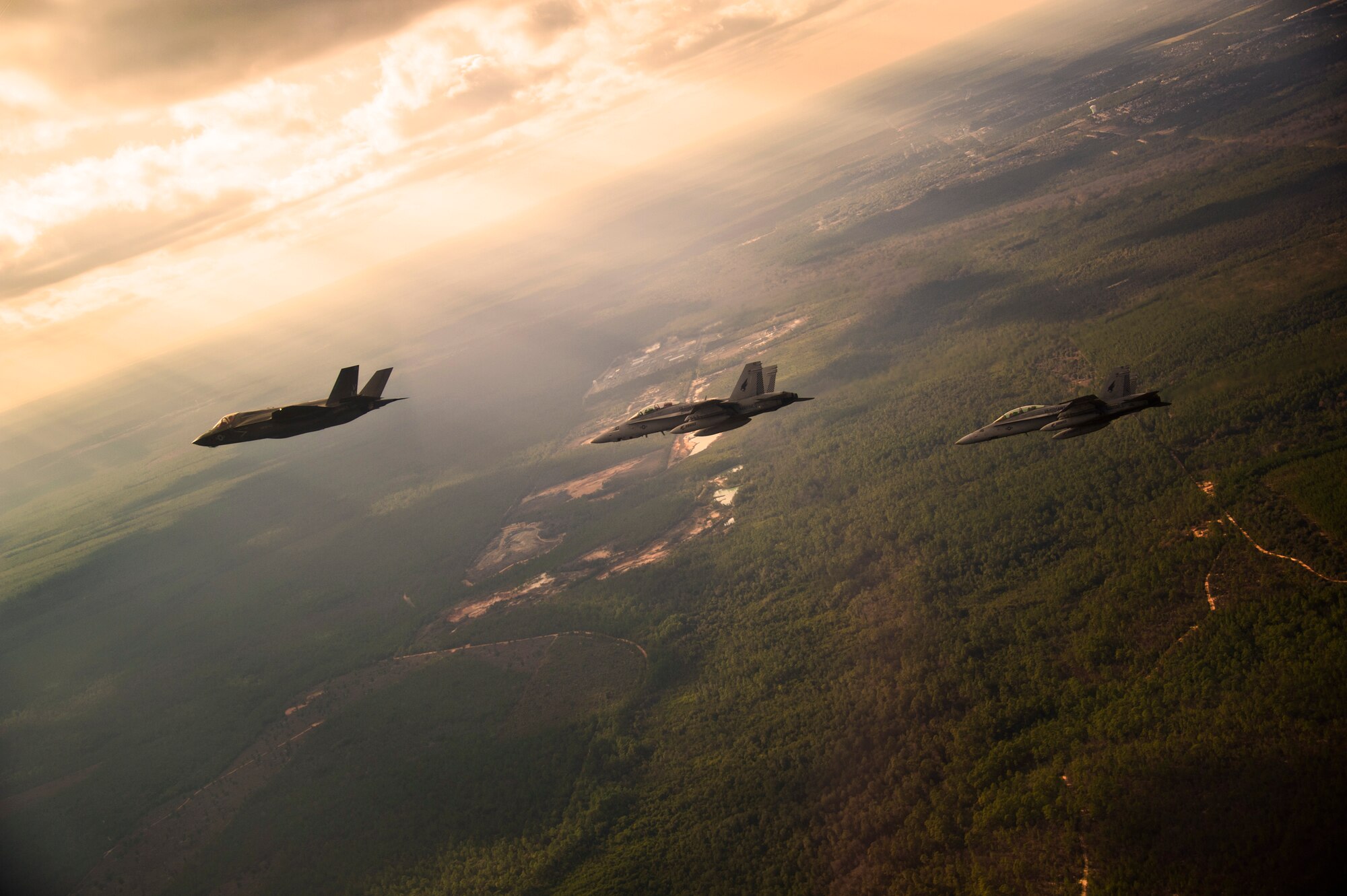 DoD’s first production F-35B Lightning II joint strike fighter flies toward its new home at Eglin Air Force Base, Fla., escorted by Marine Corps F-18 Hornets.  The Marine variant of the JSF belongs to Marine Fighter Attack Squadron 501.  The Marines of VMFAT-501 received two F-35Bs Jan. 11.  (U.S. Air Force photo/Staff Sgt. Joely Santiago)