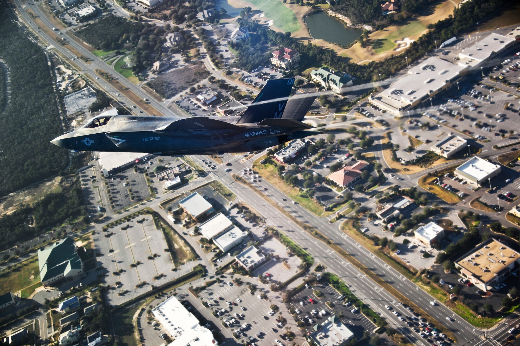 DoD’s first production F-35B Lightning II joint strike fighter soars over Destin, Fla., on its way to its new home at Eglin Air Force Base, Fla.  The Marine variant of the JSF belongs to Marine Fighter Attack Squadron 501.  The Marines of VMFAT-501 received two F-35Bs Jan. 11.  Both aircraft were escorted in by Marine F-18 Hornets.  (U.S. Air Force photo/Staff Sgt. Joely Santiago)