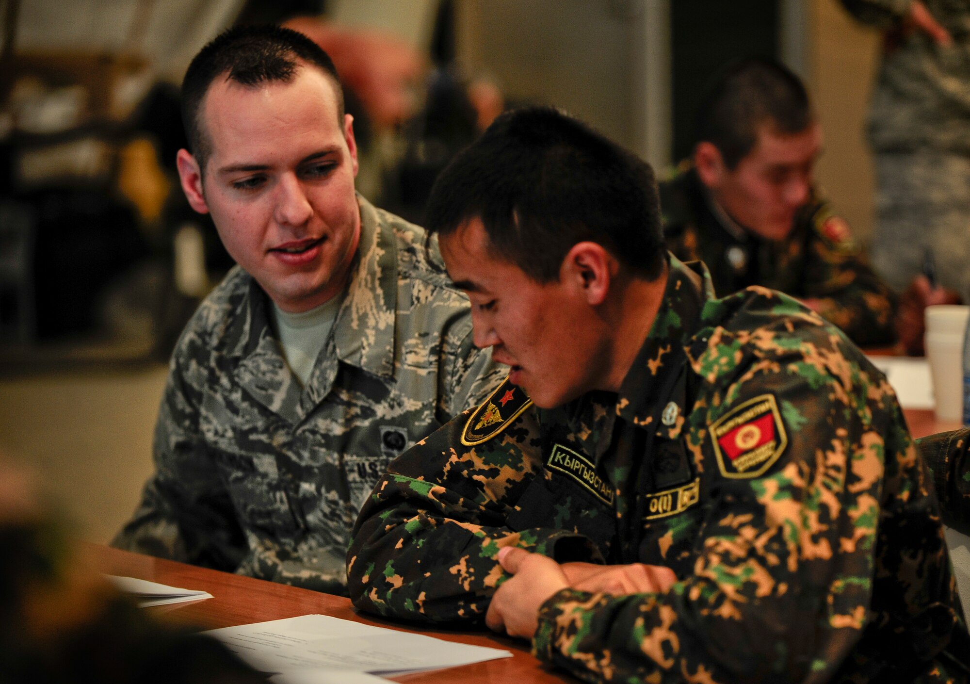 Senior Airman Thomas Adkinson collaborates with Kyrgyz Republic Sgt. Erlan Asangozier Jan. 12, 2012, during the Koi Tash language exchange on the Transit Center at Manas, Kyrgyzstan. There were 22 people that attended the language exchange between U.S. Air Force Airmen assigned to the Transit Center and the Koi Tash Noncommissioned Officer Academy. Adkinson is a personnel support for contingency operations representative with the 376th Force Support Squadron deployed here from Vance Air Force Base, Okla. (U.S. Air Force Photo/Staff Sgt. Angela Ruiz)