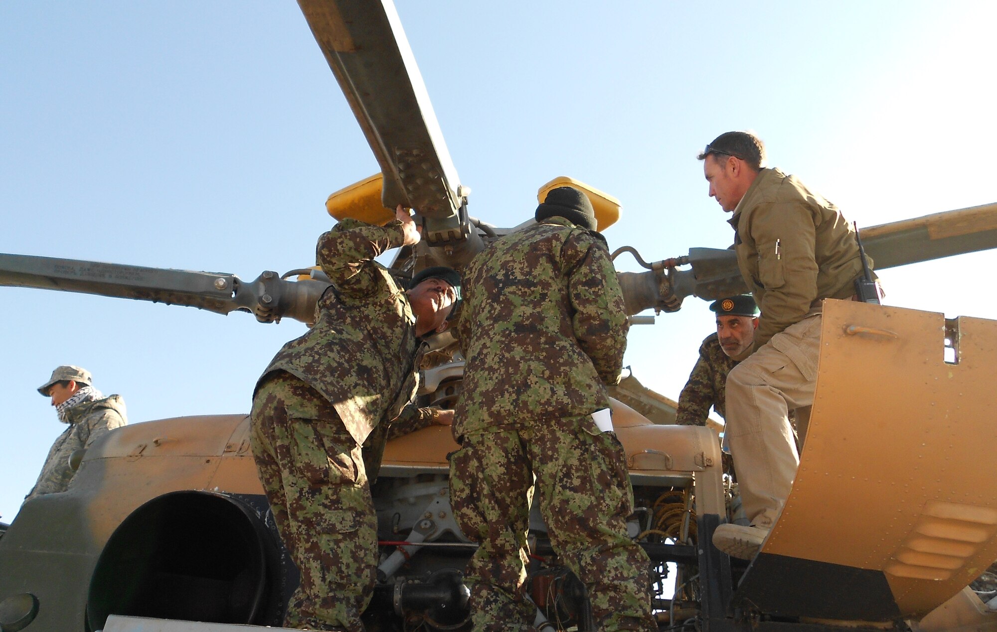 Afghan air force maintenance personnel inspect the rotor of a MI-17 as an adviser looks on. (courtesy photo)